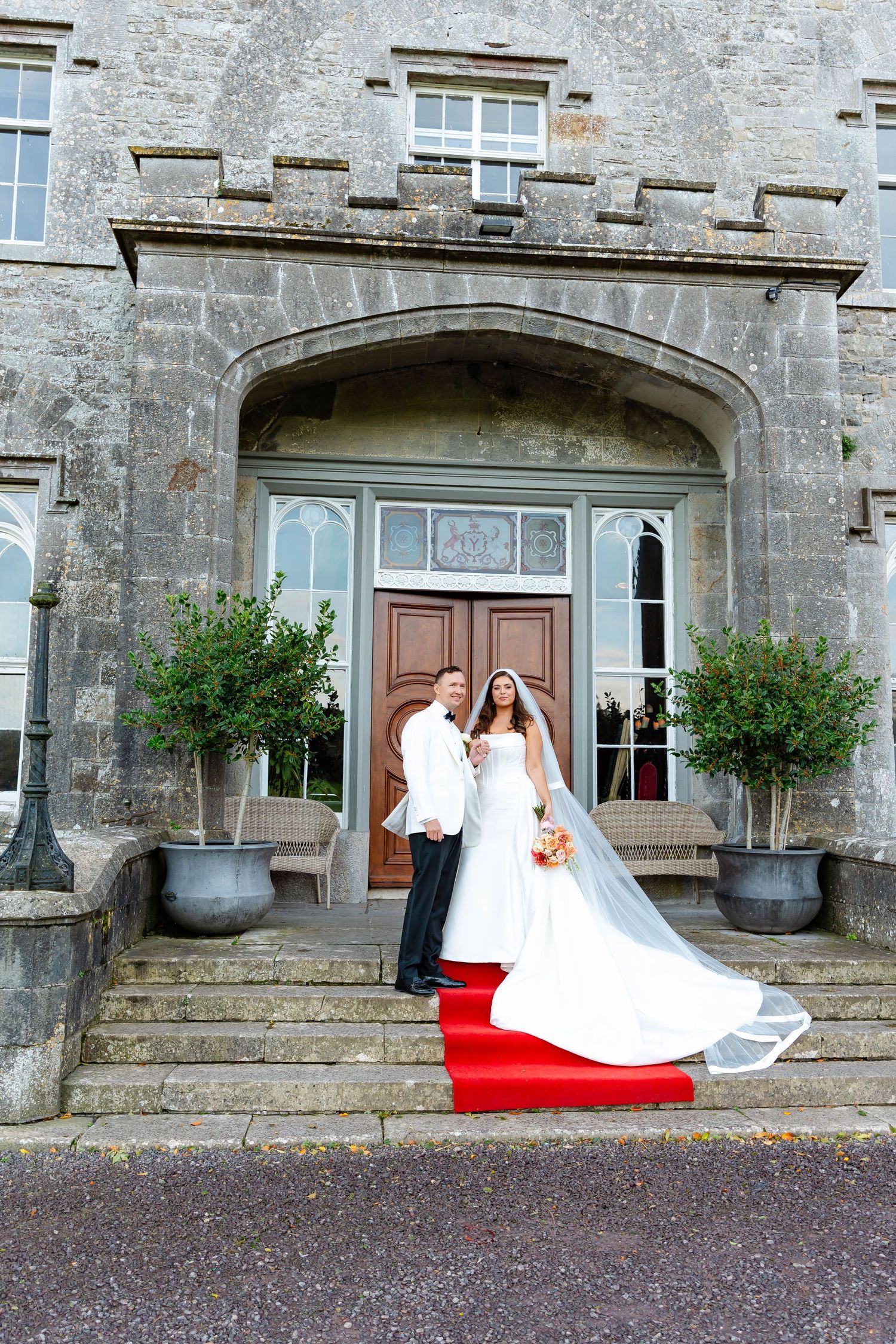 A sequence of five wedding photos showing a couple on the steps of a historic stone building with a red carpet.