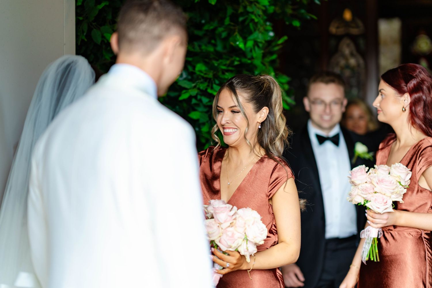 Wedding party members share emotional moments during celebration in outdoor garden setting.