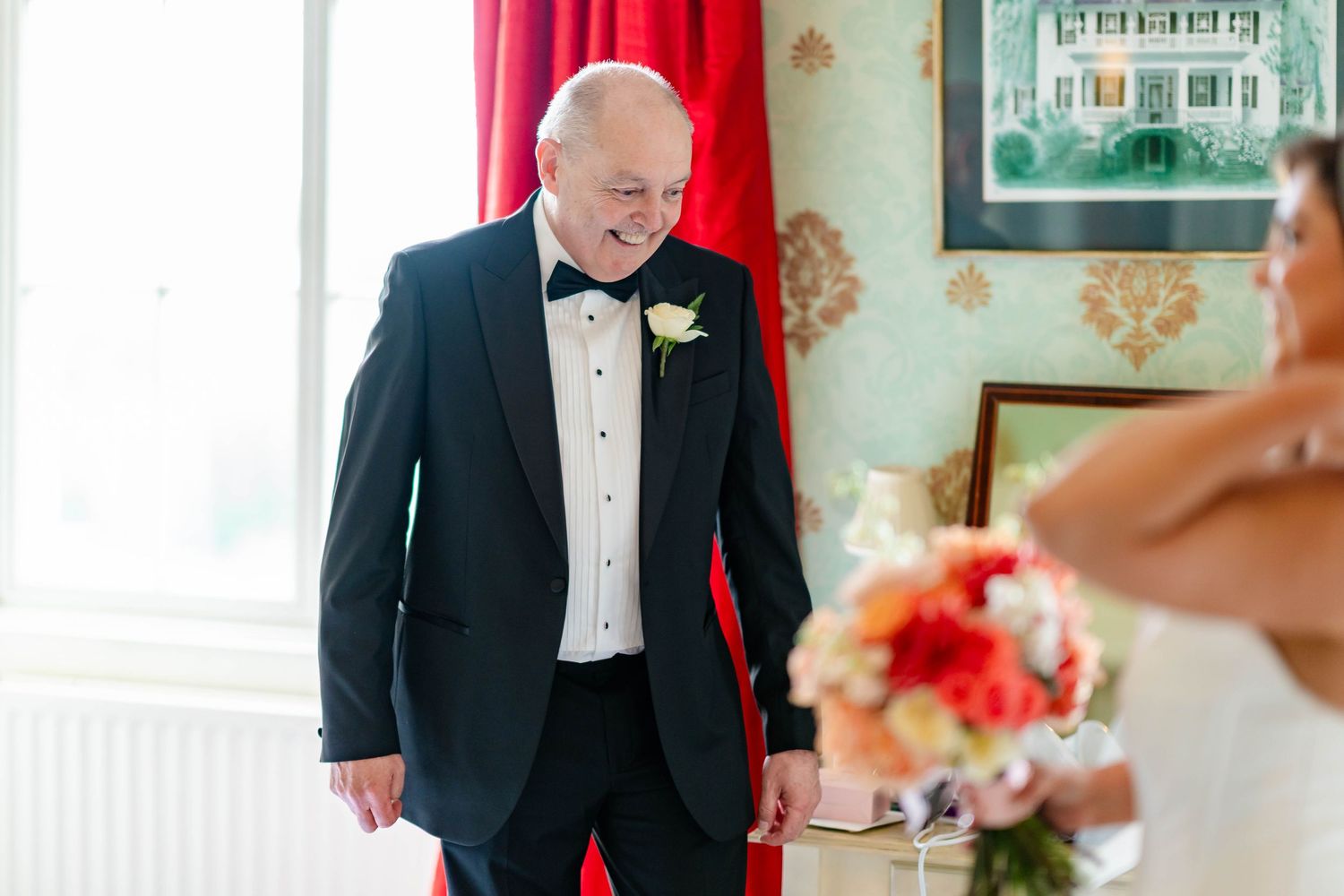 Emotional first look moment at wedding as groom in black tuxedo sees bride for the first time.