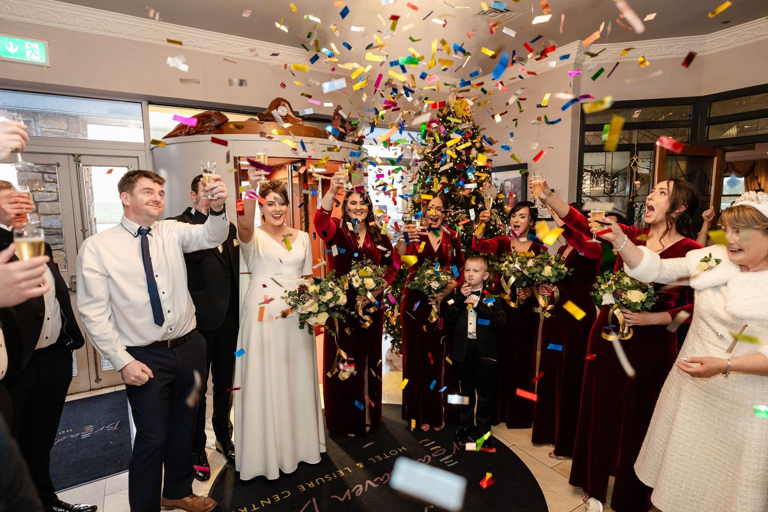 Wedding reception celebration with colorful confetti shower in an elegantly lit indoor venue.