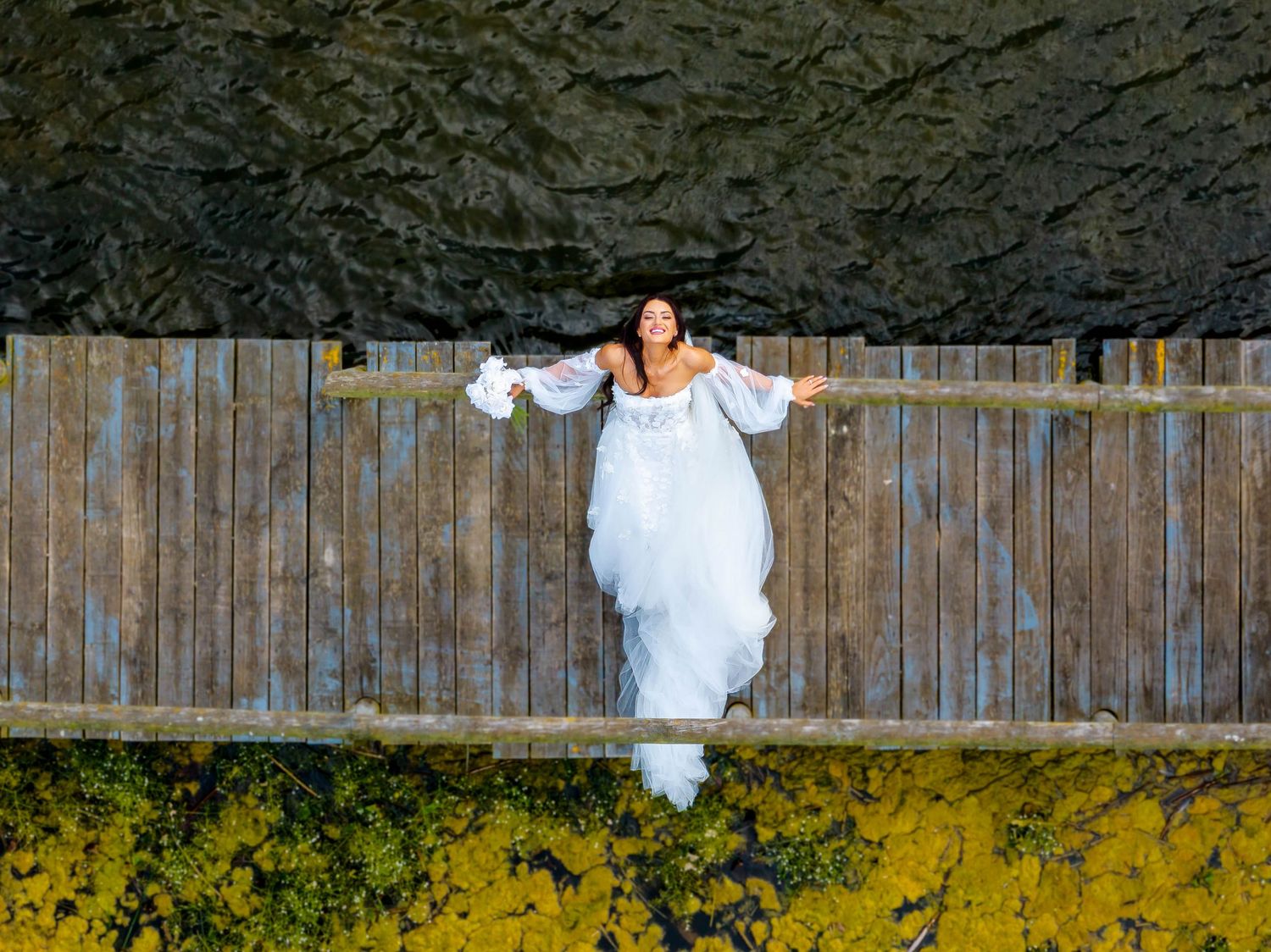 Rustic wooden fence backdrop with flowing white fabric in an outdoor setting.
