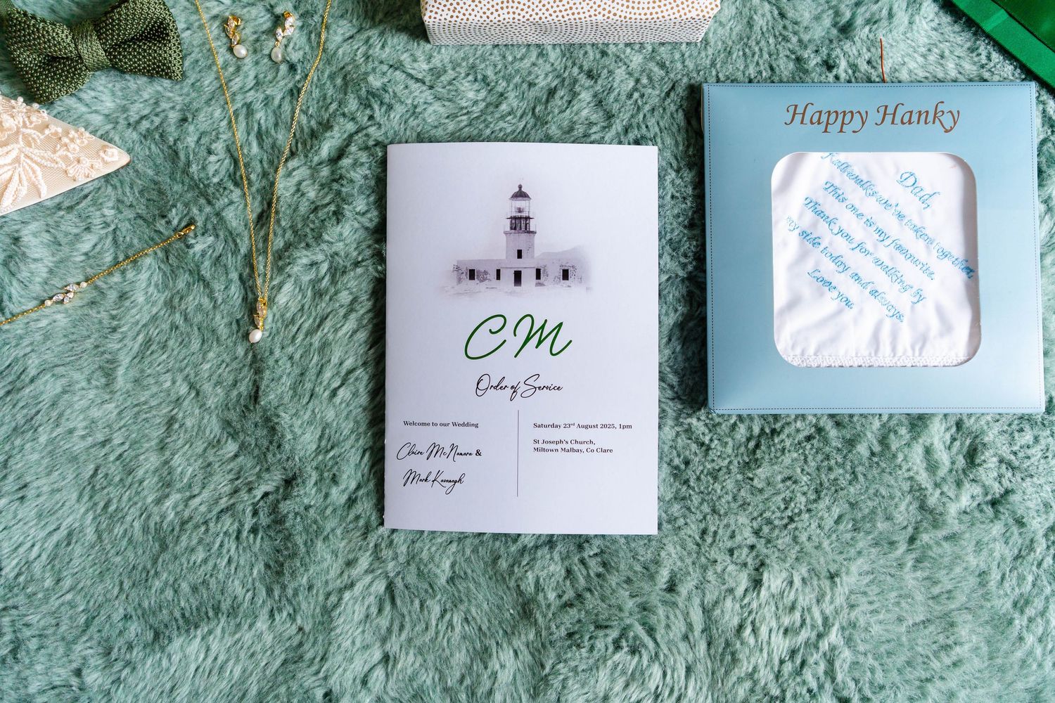 Wedding stationery and invitations displayed on textured turquoise wall.