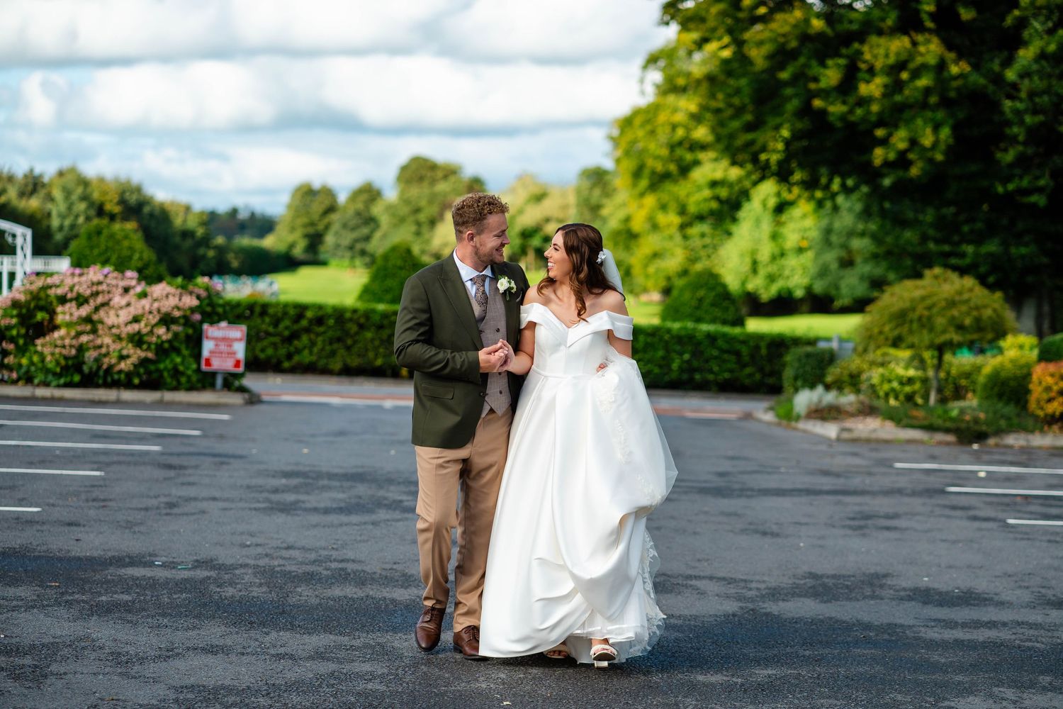 Newlyweds share romantic moments in beautiful garden setting.