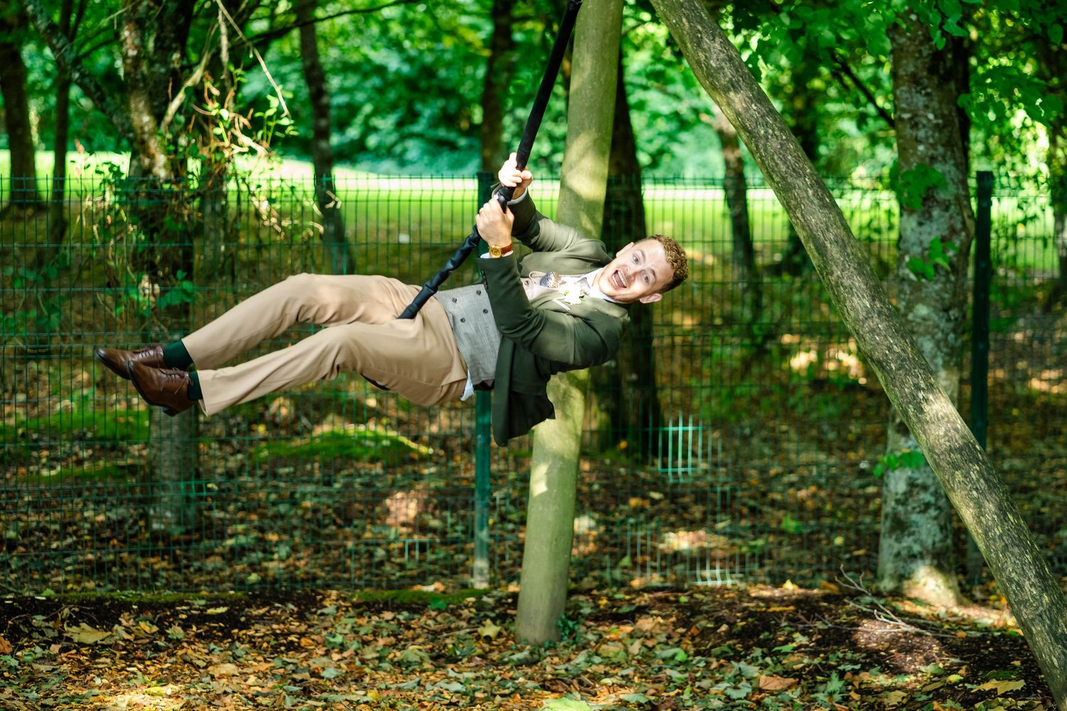 Wedding party poses for candid photos in wooded outdoor setting.