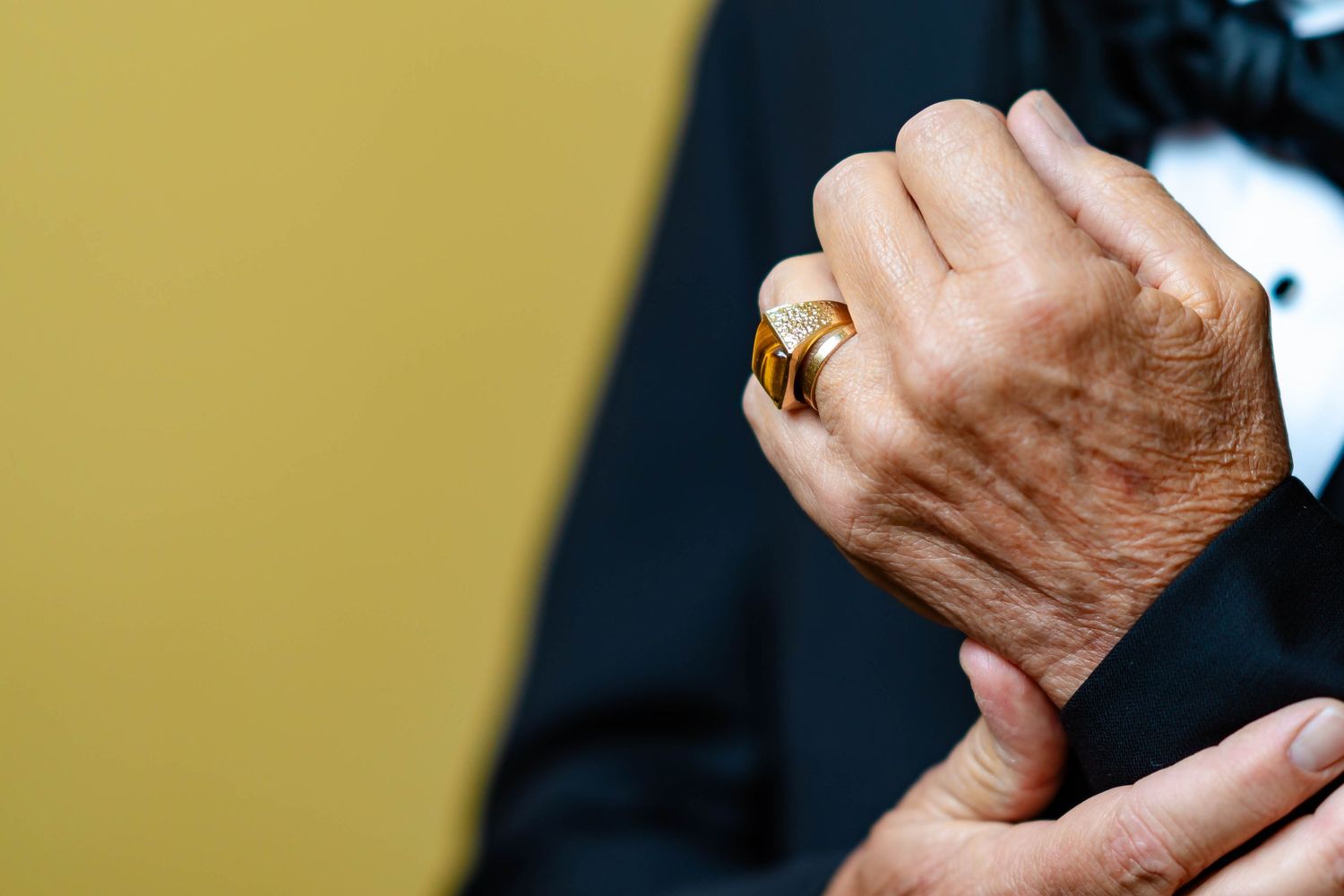 Close-up view of hands holding and examining a small object in a dimly lit setting.