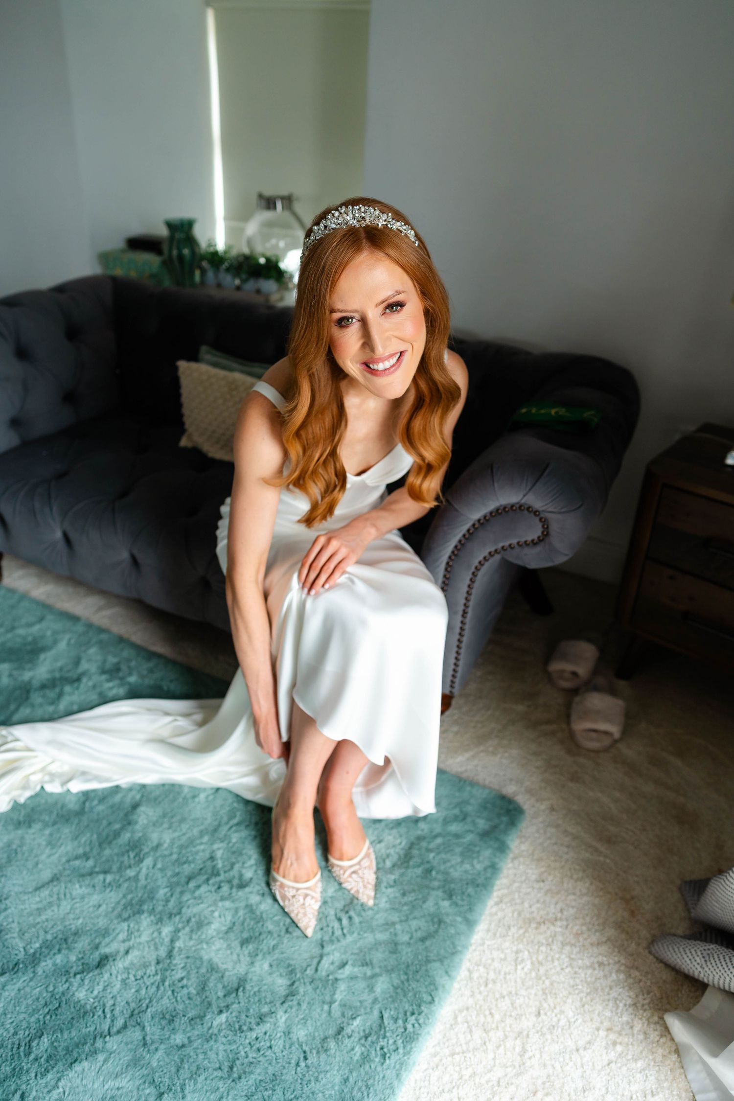 Bridal portrait session on a seafoam green rug showing elegant white dress and tiara.