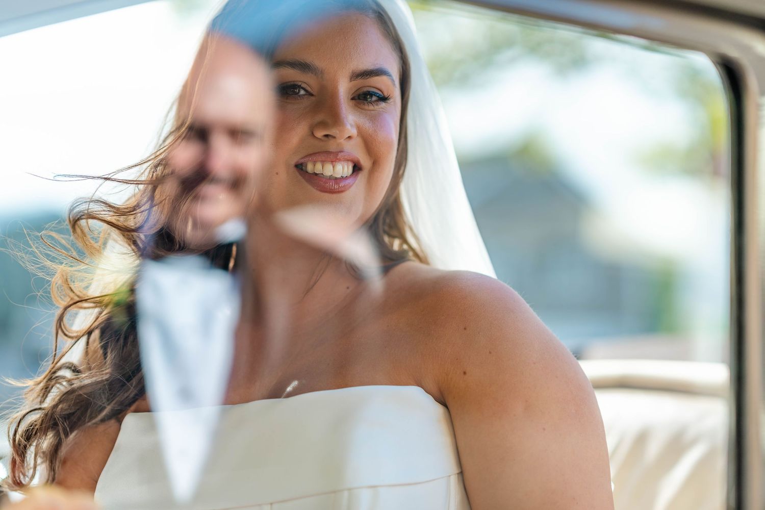 A happy couple shares a joyful moment during their wedding celebration outdoors.