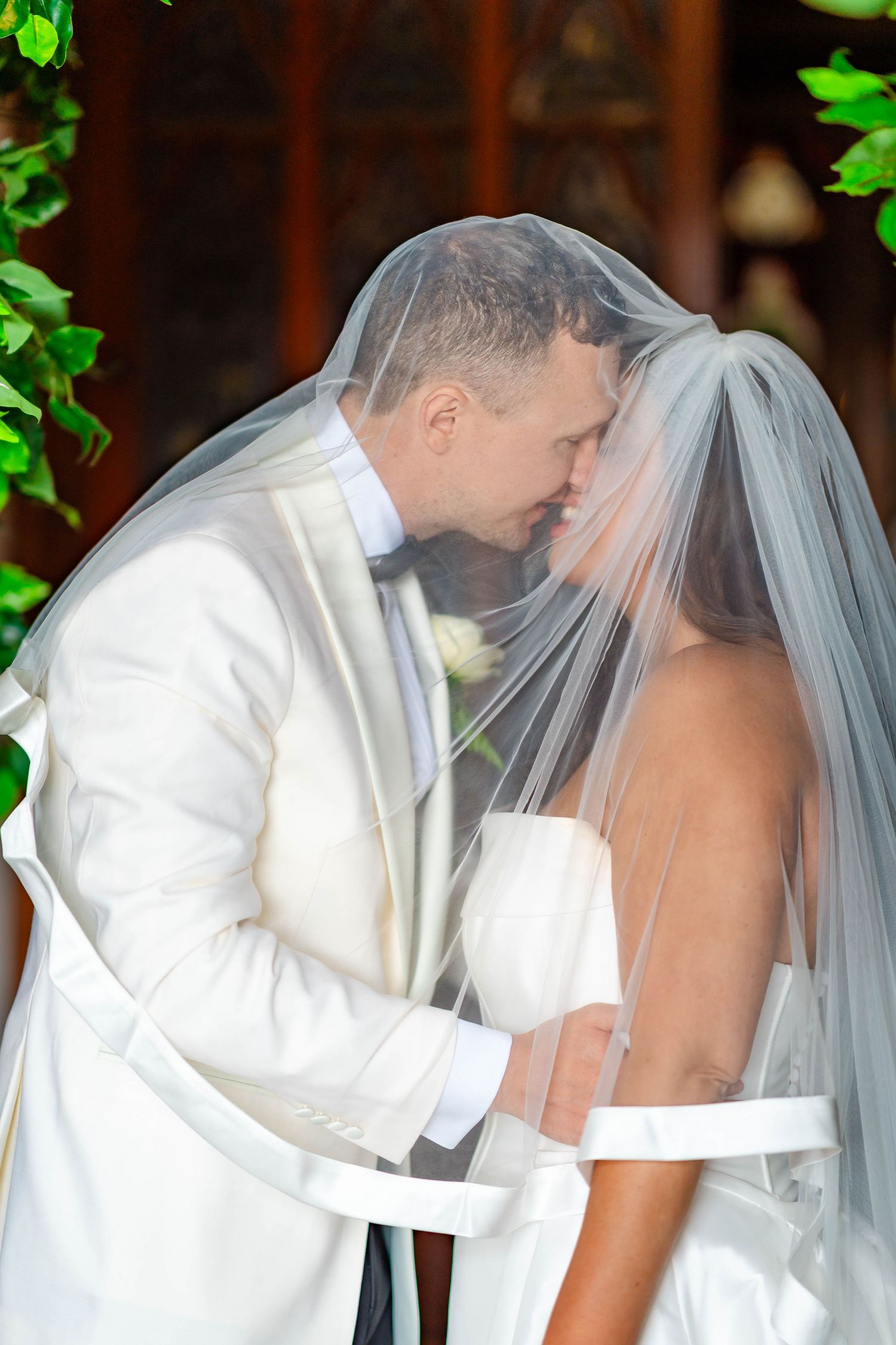 A romantic wedding kiss sequence showing a couple in white sharing their first kiss as newlyweds.