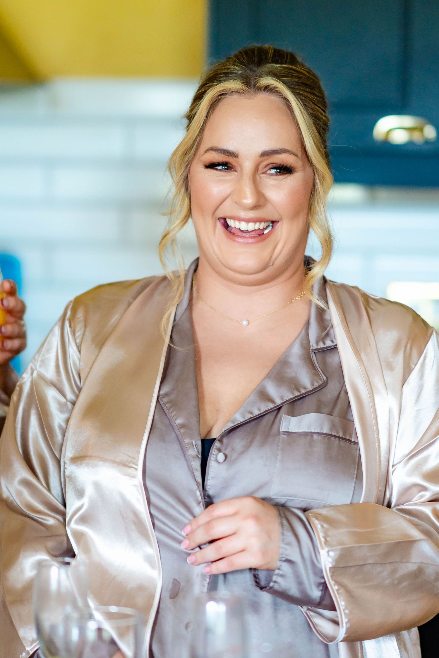 Woman in champagne silk pajamas poses in a series of expressive candid shots showing laughter and joy.
