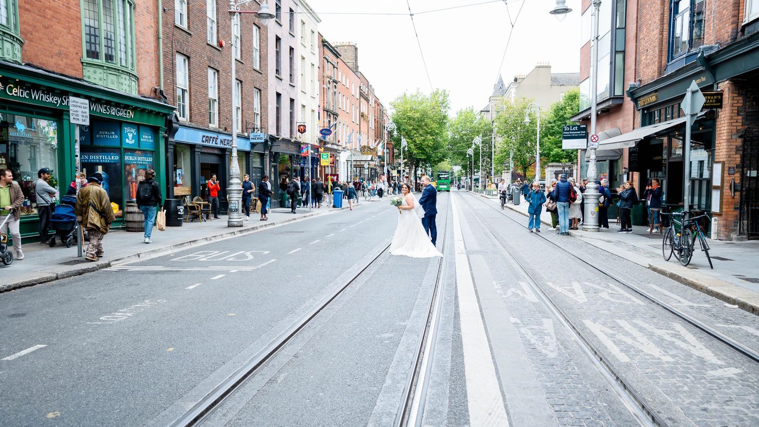 Panoramic view of Dublin street with shops and pedestrians.