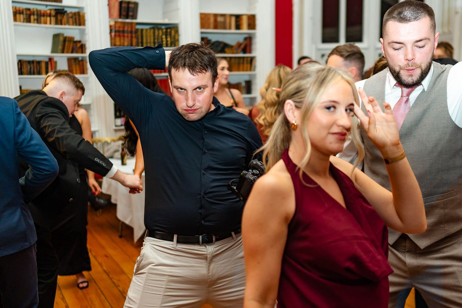 A sequence of people playing a competitive game at a party by bobbing for apples in bowls of water.