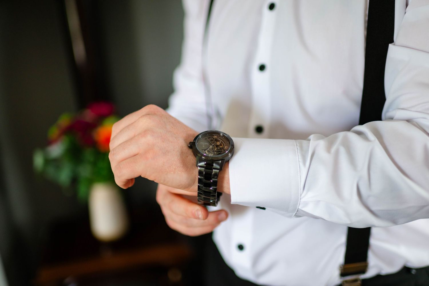 Detail shot of white dress shirt cuffs and formal wear accessories.