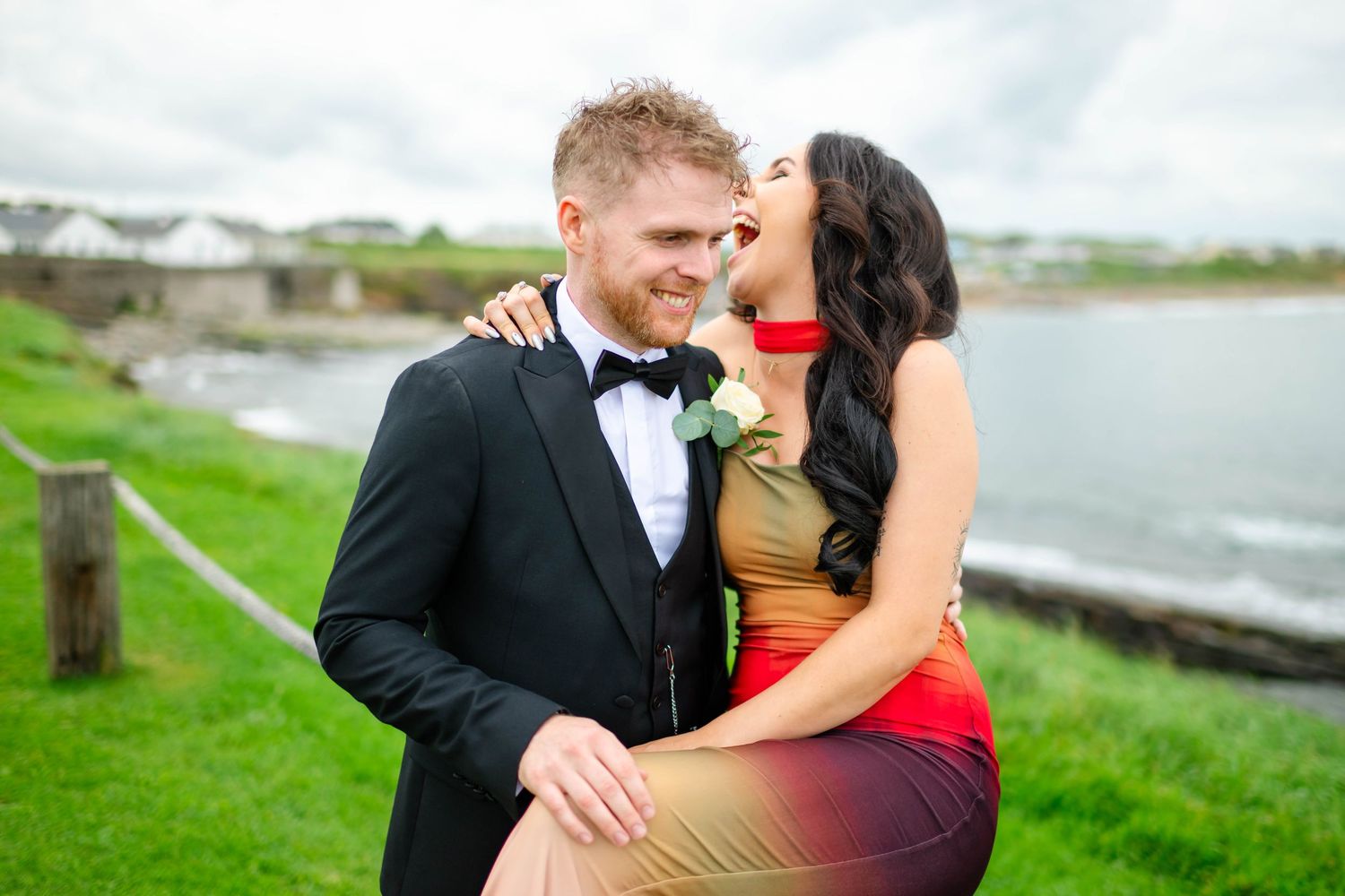 Couples share intimate moments during outdoor celebration by the ocean.
