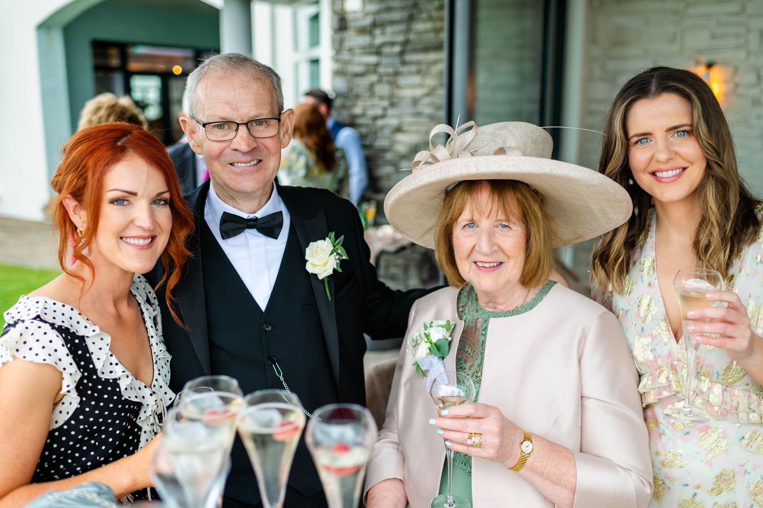 Wedding guests enjoying drinks and conversation at outdoor reception.