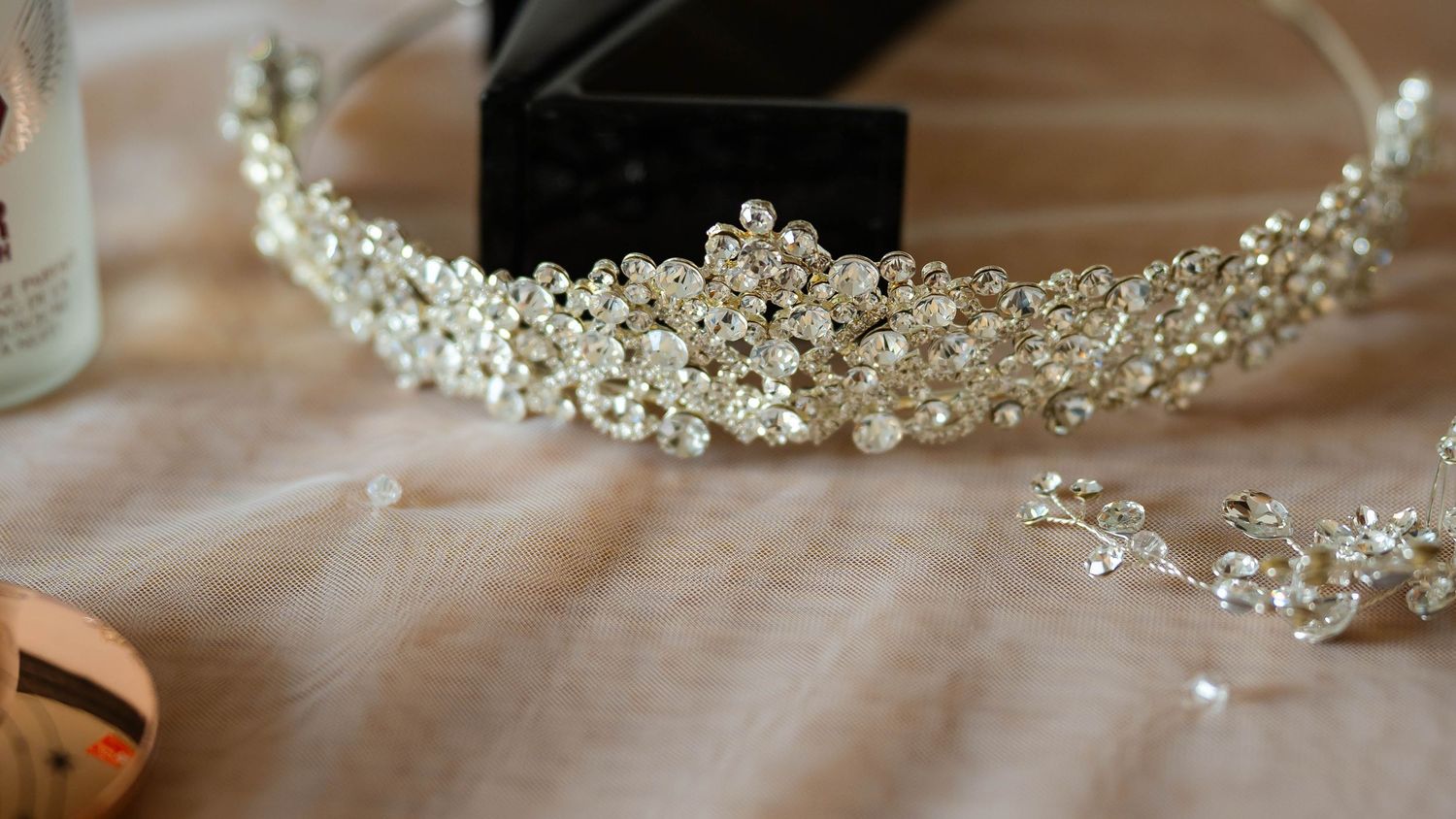 Delicate pearl and crystal wedding accessories displayed on a soft surface.