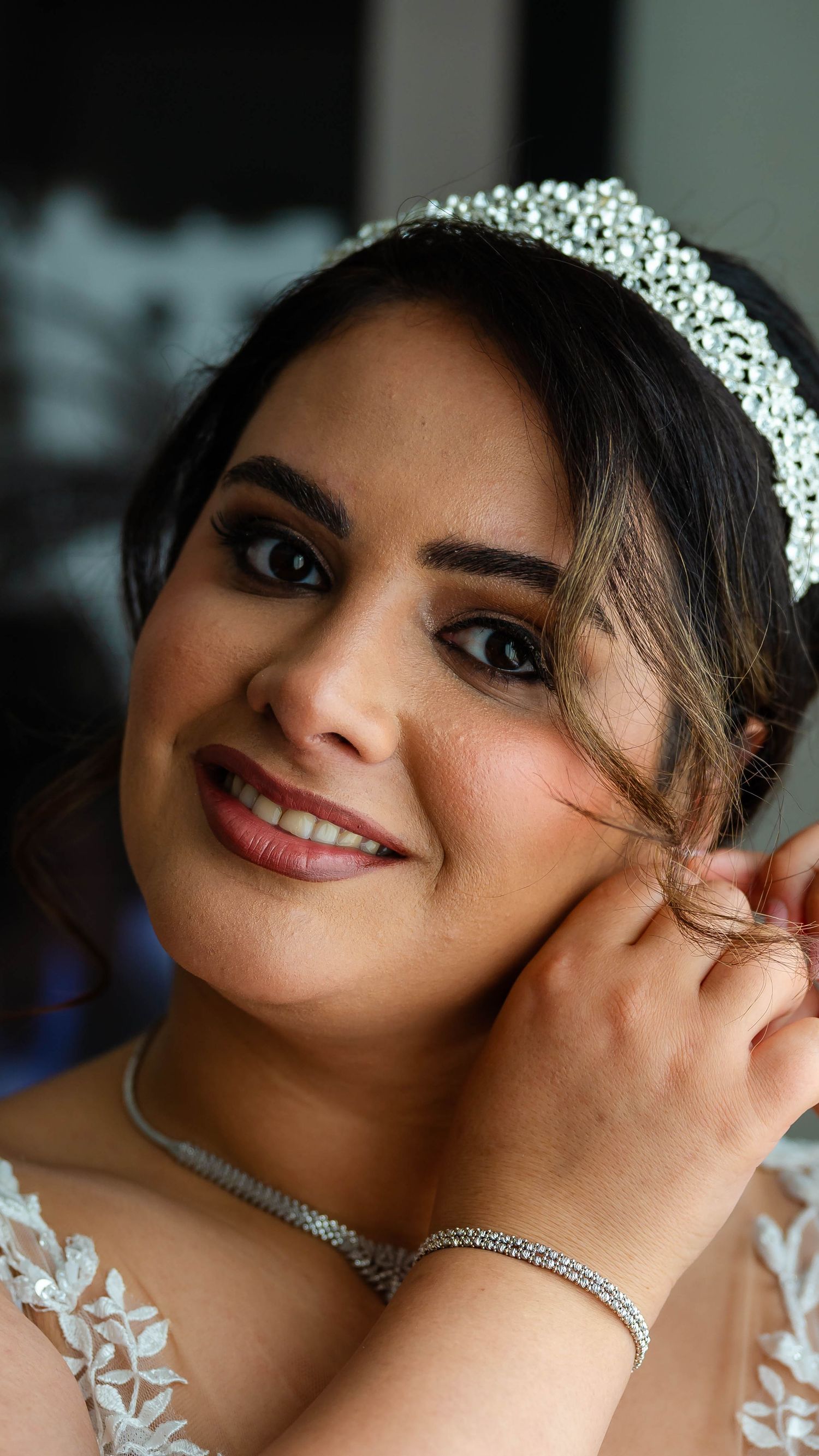 Bride wearing an elegant tiara and lace dress adjusts her jewelry in a series of candid shots.