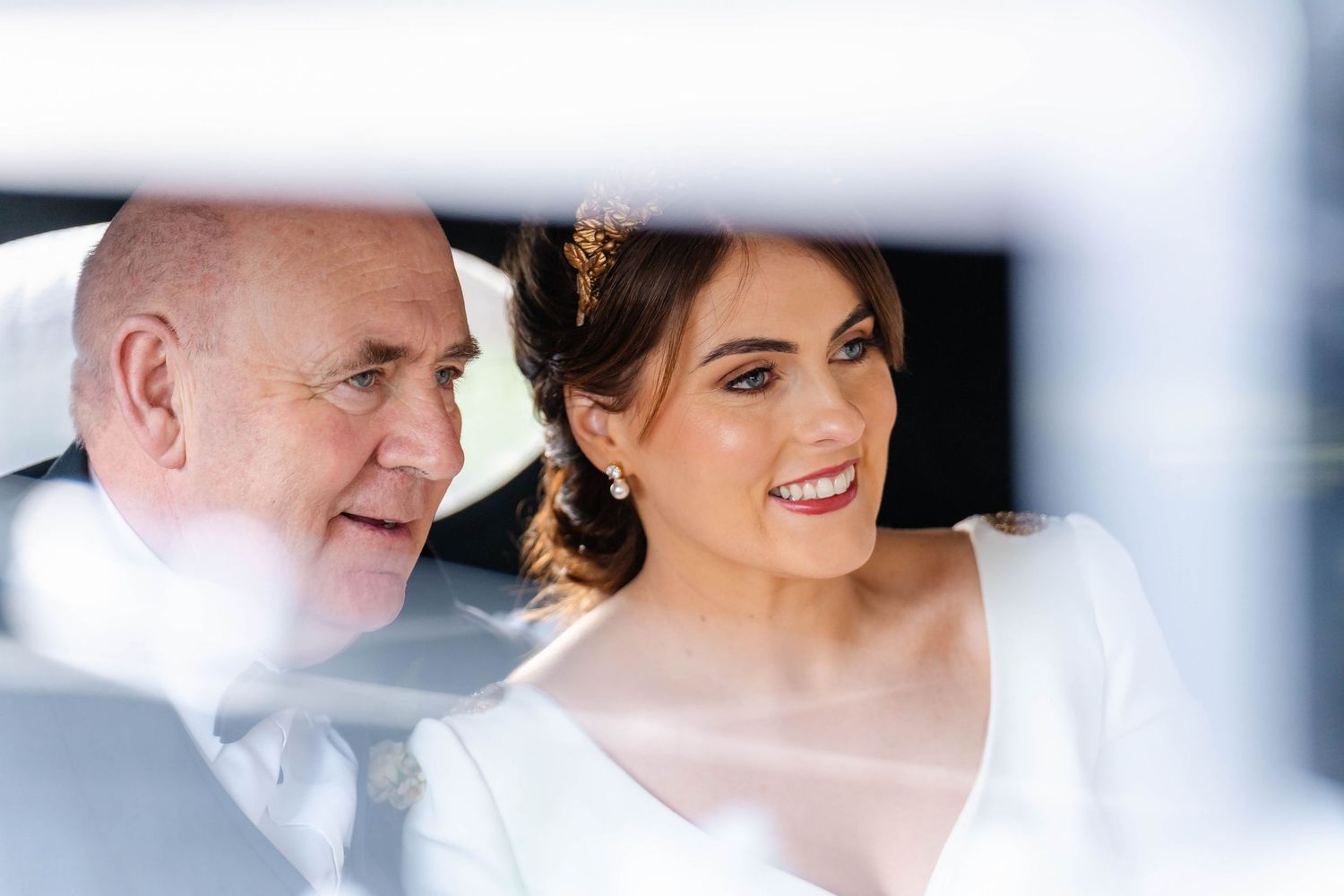Close-up artistic wedding photography with soft focus and white tones.
