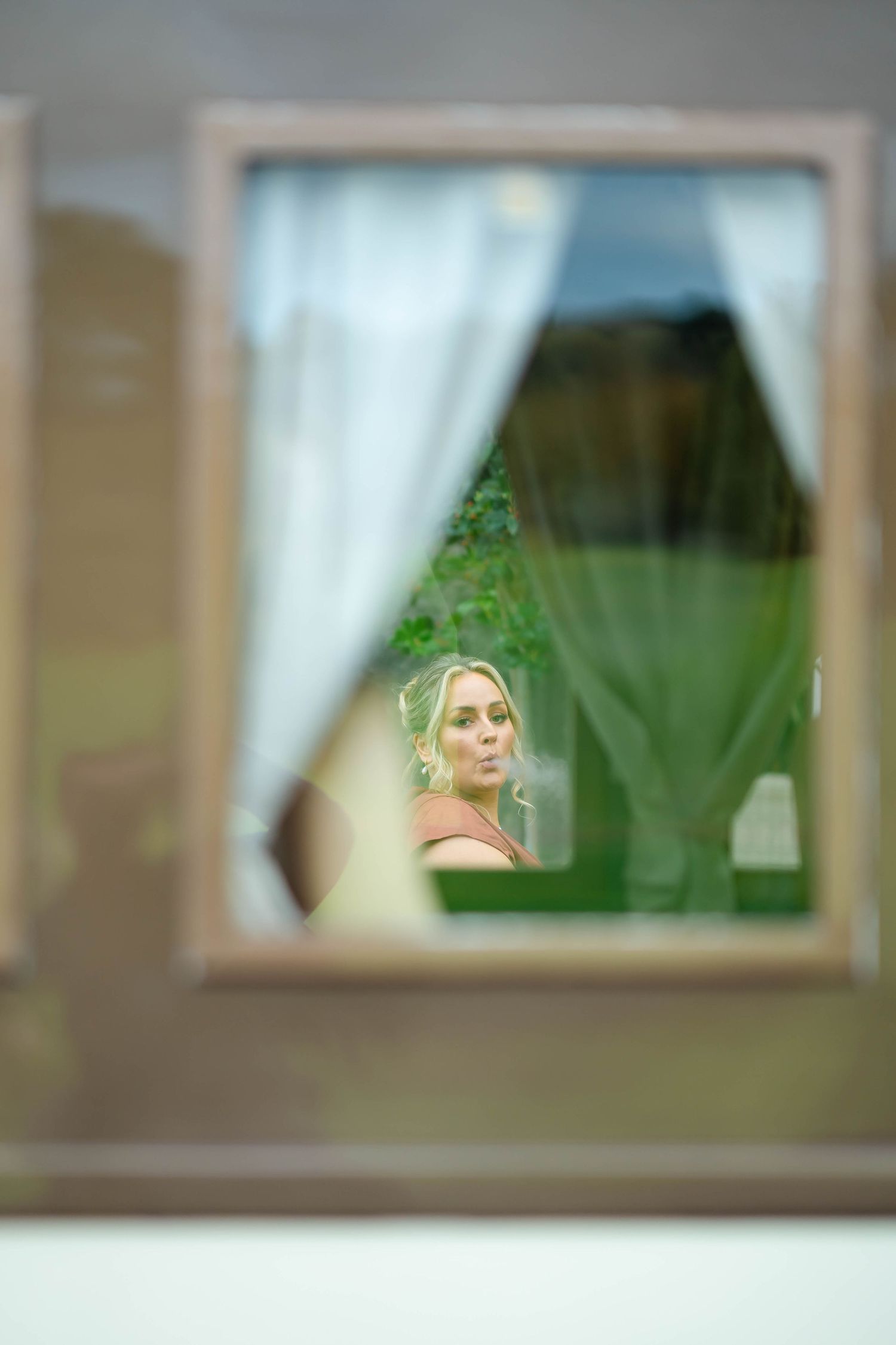 A sequence of windows with sheer white curtains shows a progressively blurred view from left to right.