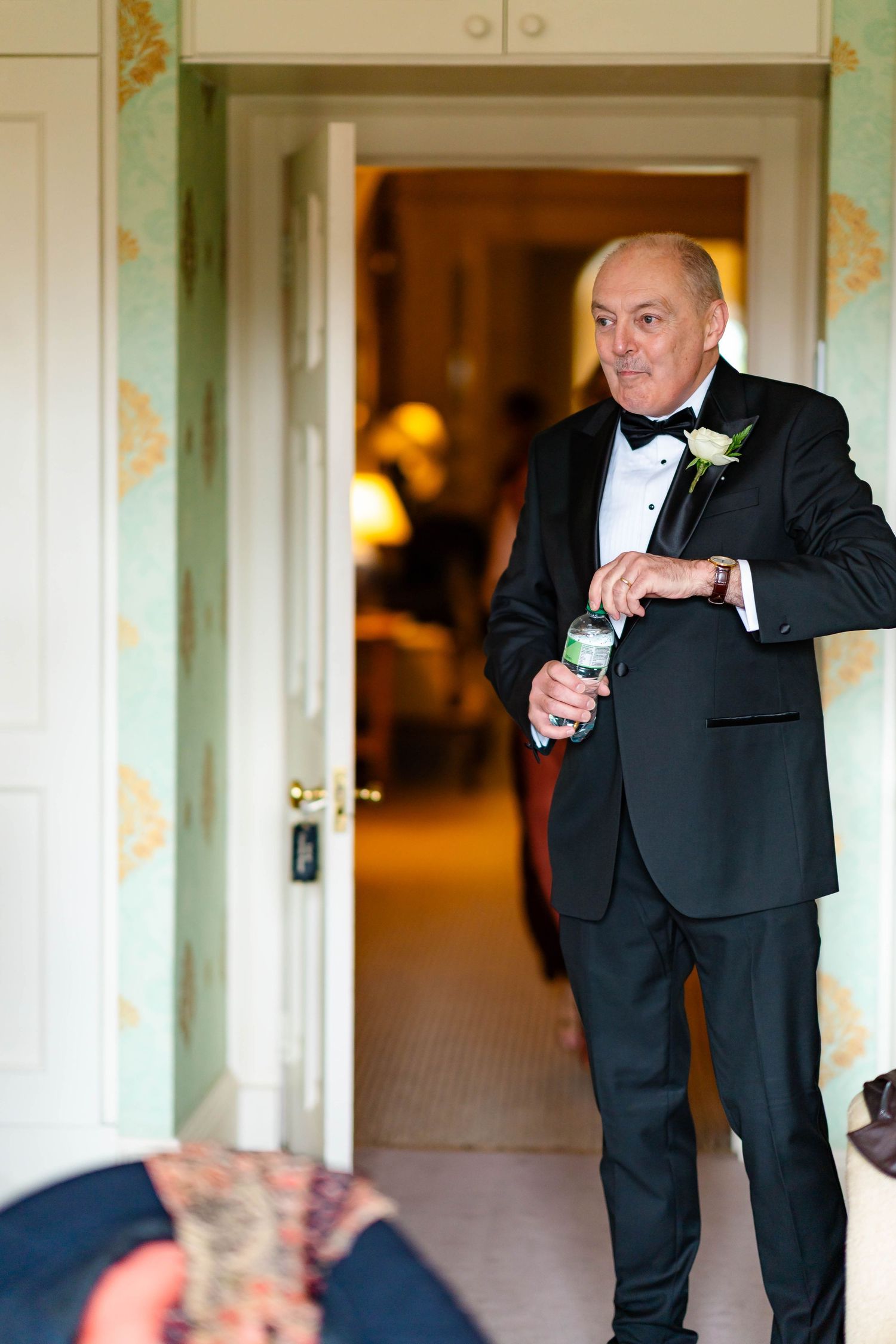 Three photos show a person in a black tuxedo gesturing while giving a speech at an elegant indoor event.