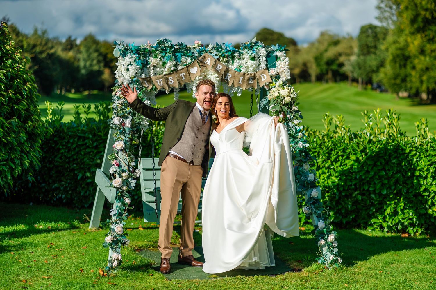 Outdoor wedding portraits with lush greenery and cloudy sky backdrop.