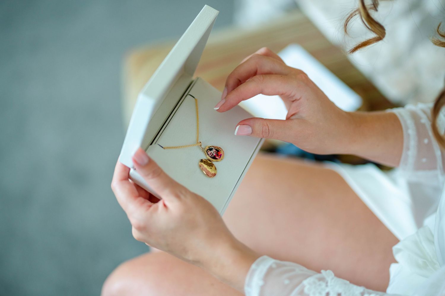 Wedding morning preparation details with hands holding invitation card.