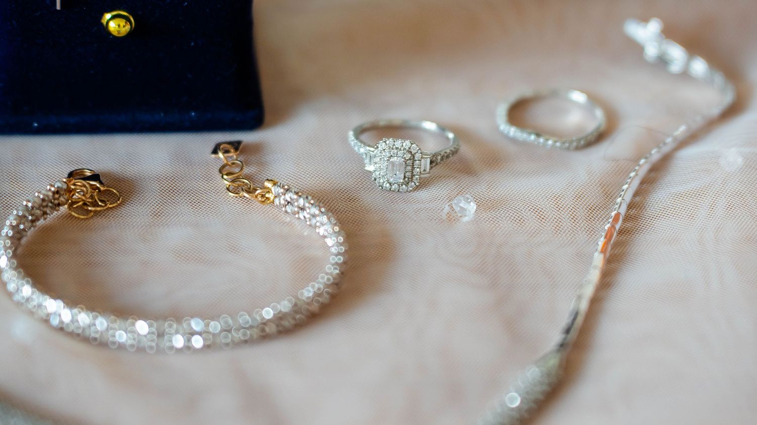 Close-up detail shots of sparkling wedding jewelry and accessories on dark background.