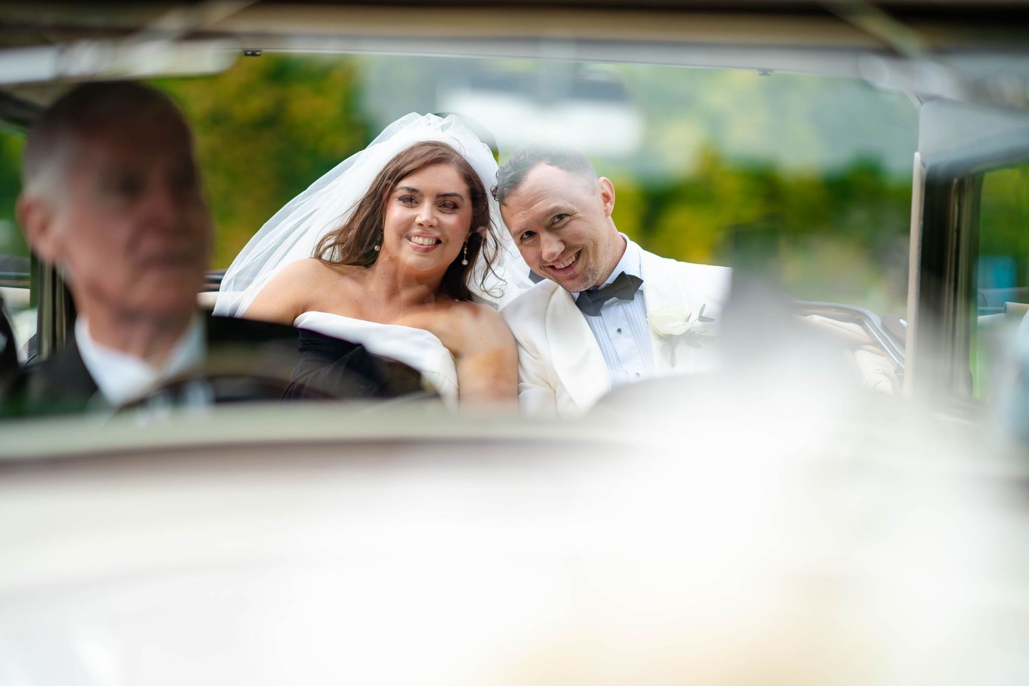 A bride and groom share a joyful moment while posing outdoors for their wedding photos.
