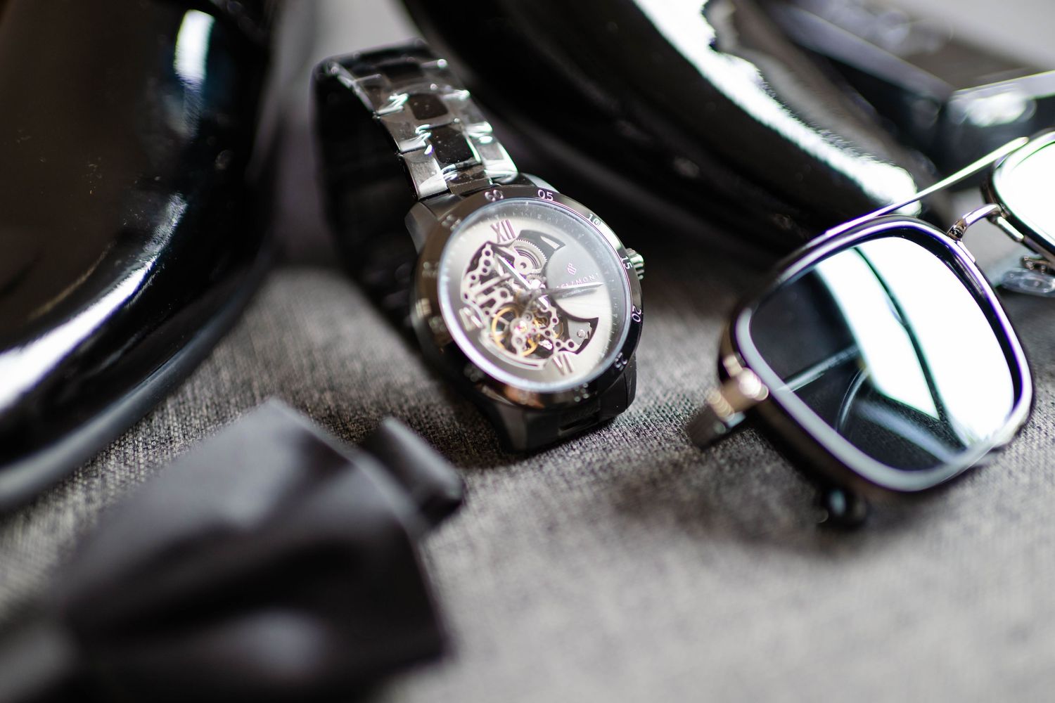 Close-up details of luxury watches and wedding accessories on a dark surface.