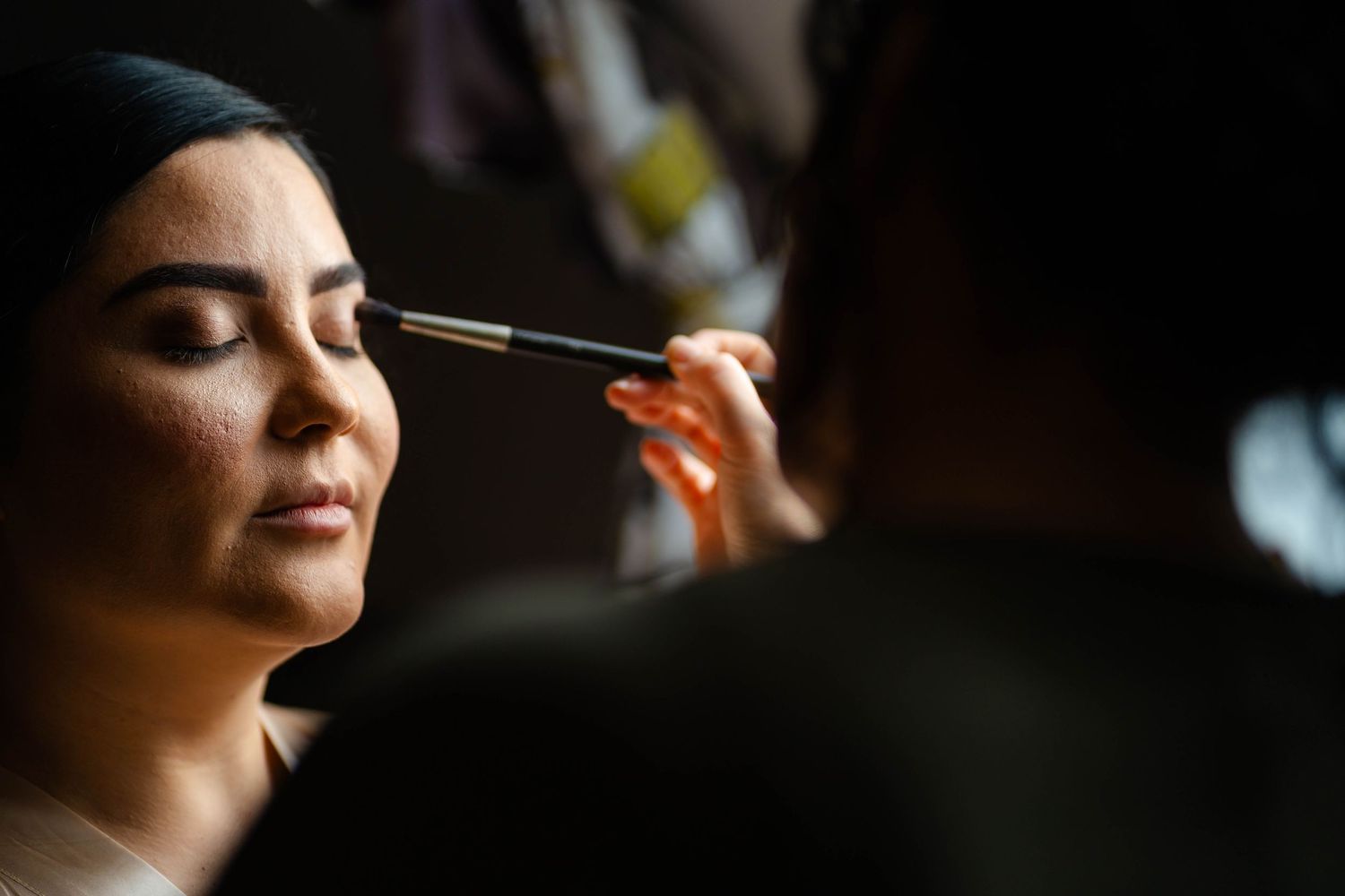 Close-up shot of makeup application during wedding preparation.