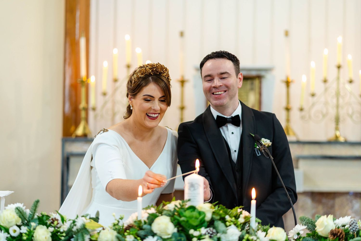 Wedding reception candlelit table settings with floral centerpieces and festive decor.