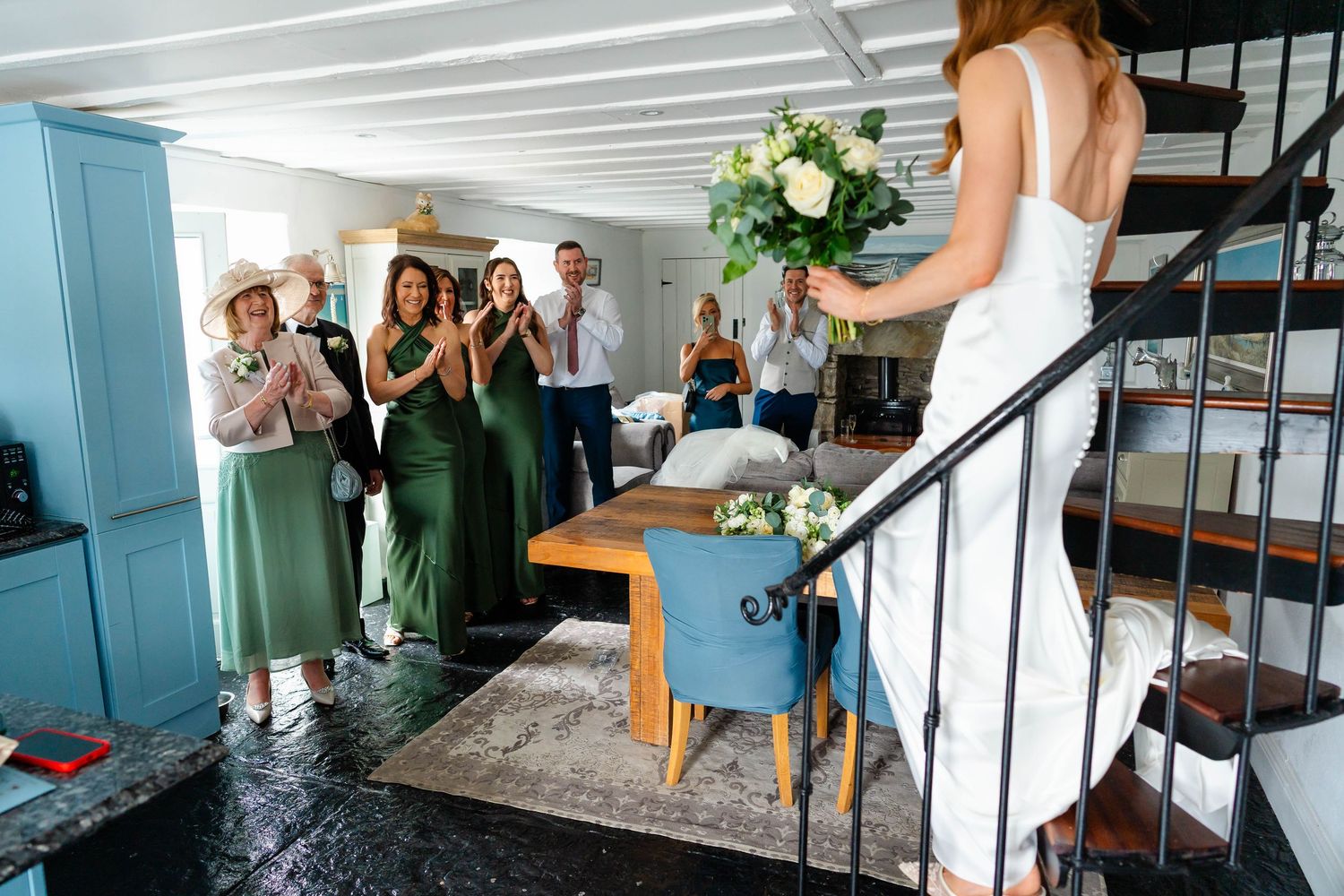 Wedding party group photo in indoor venue with blue and white decor.