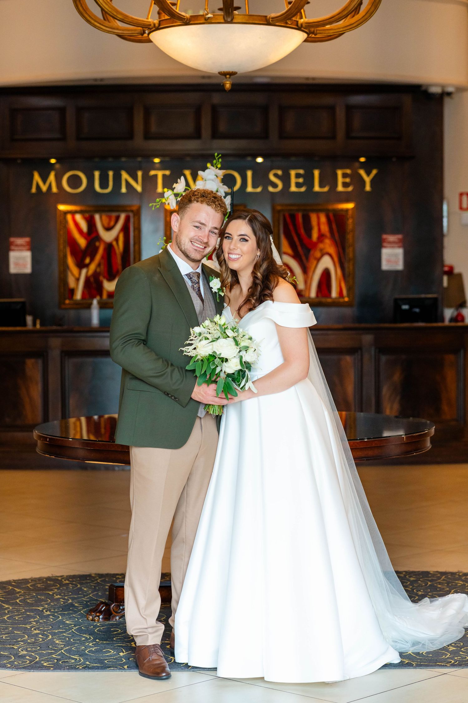 Wedding couple poses at Mount Polseley venue with elegant chandelier and decor.