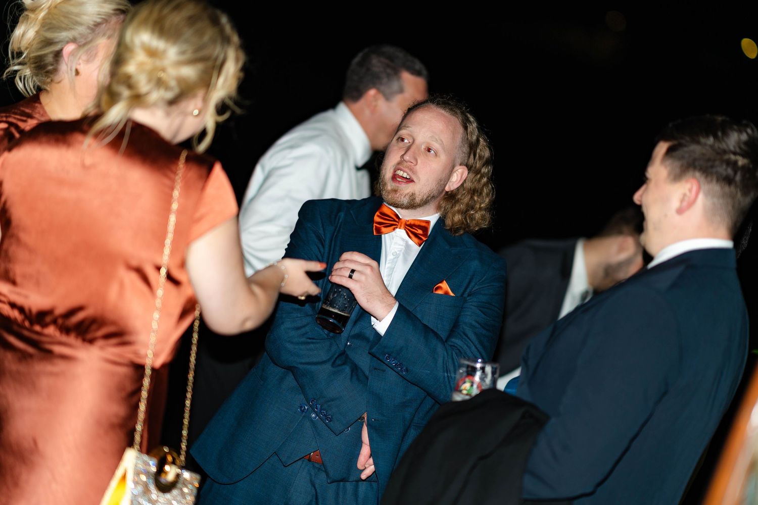 Candid party scene showing people interacting and drinking at a social gathering.