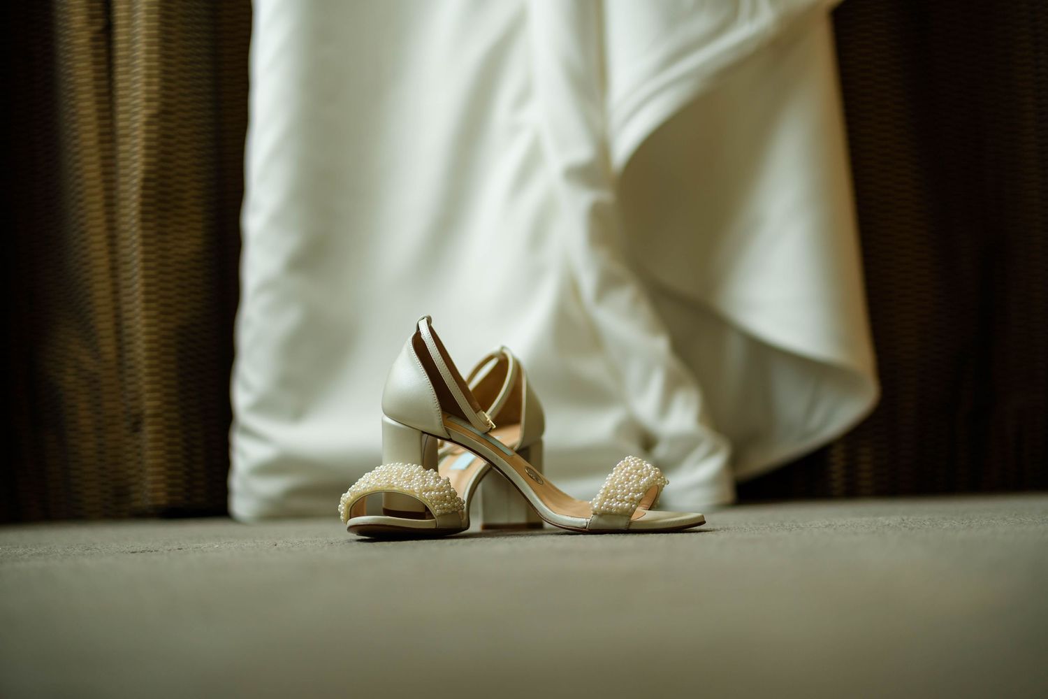 Close-up of elegant bridal shoes lined up against a light background.
