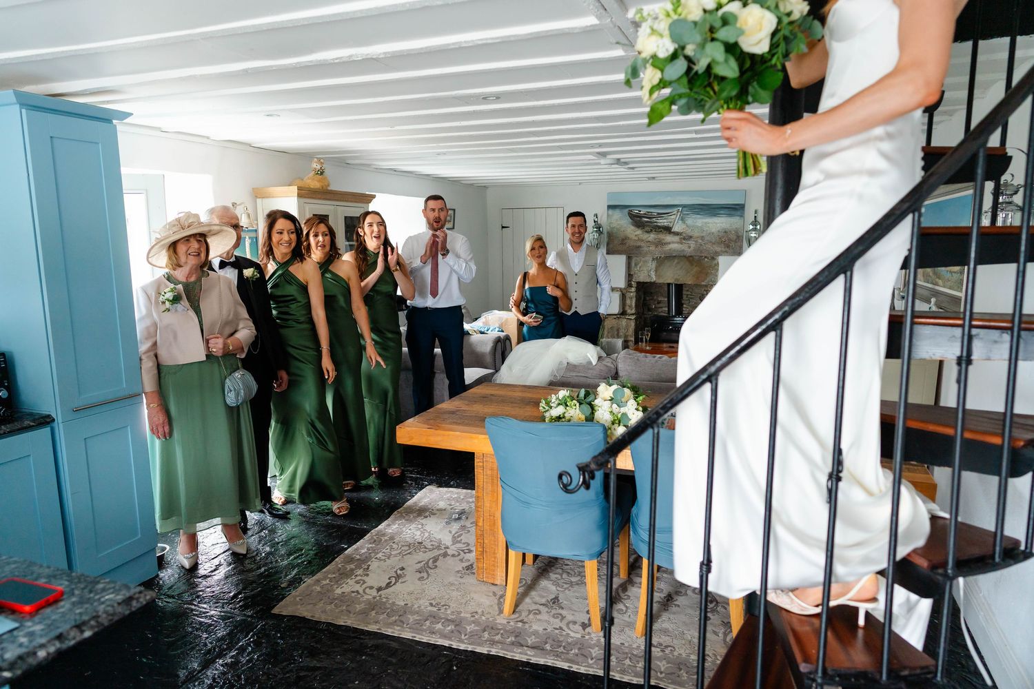 Wedding party gathered in bright indoor venue with white and teal interior.