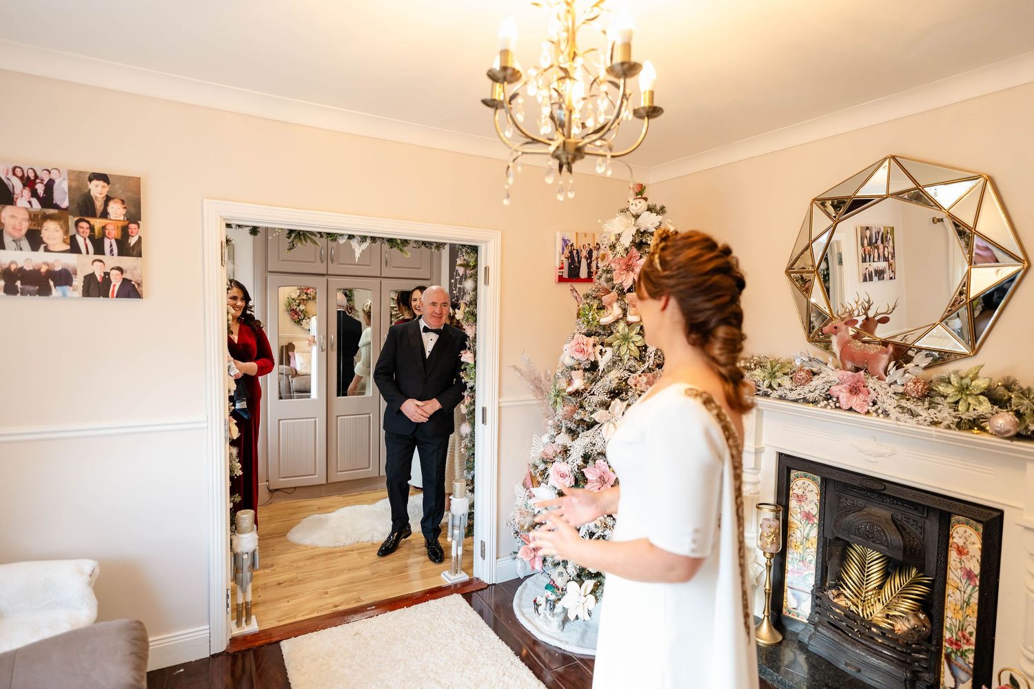 Wedding dress details and decor displayed in an elegant room with chandelier and hardwood floors.