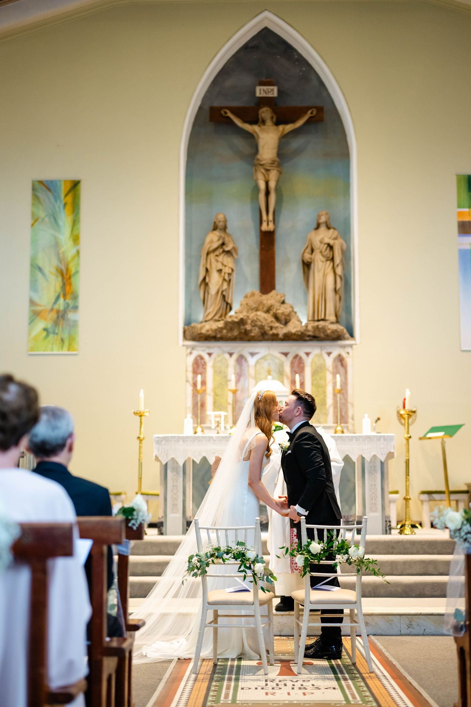 Church altar with crucifix, candles and gothic arches during wedding ceremony.