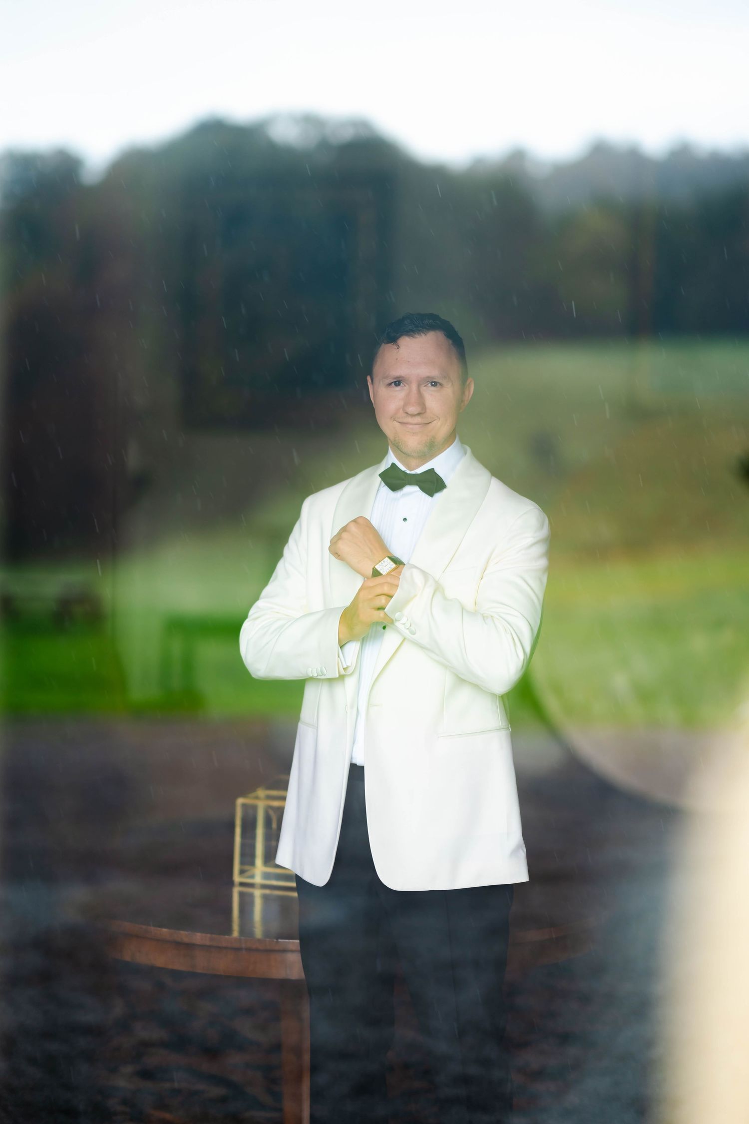 A person in a white suit jacket poses in a series of four professional portraits against a blurred outdoor background.