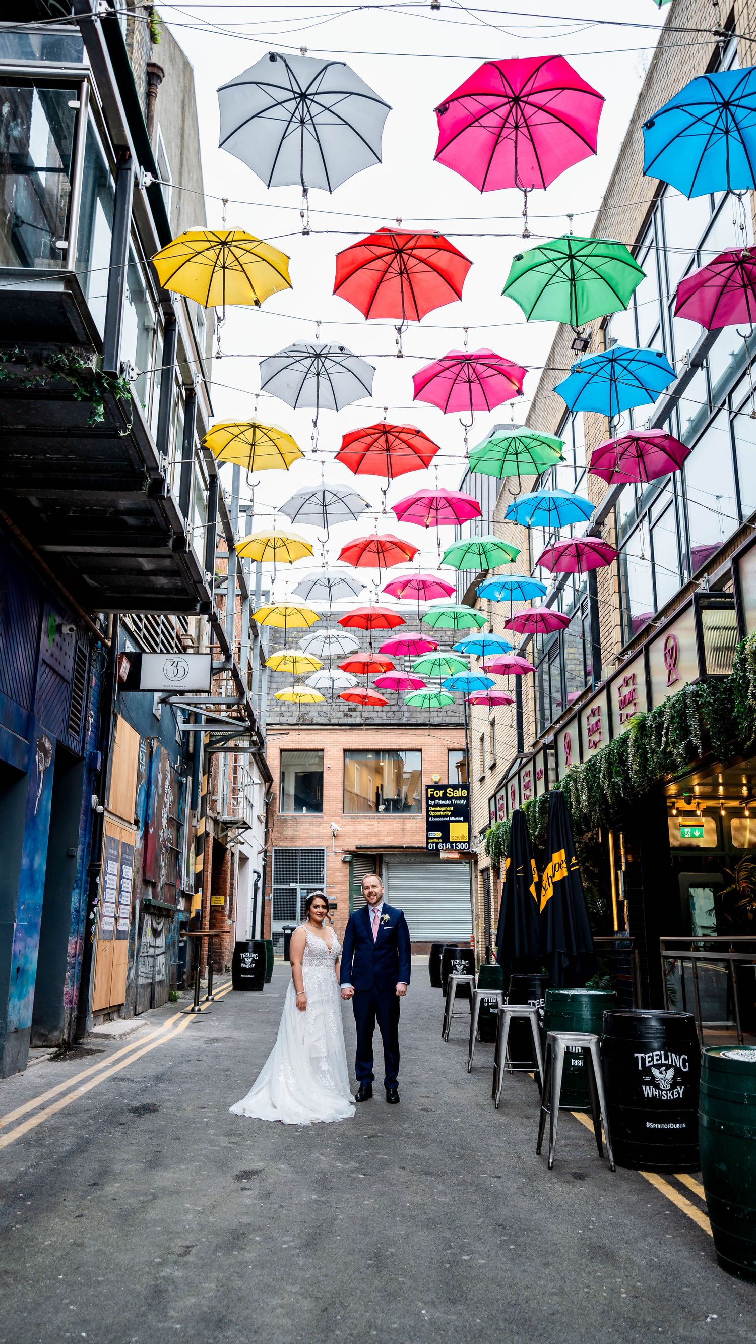 Colorful umbrellas hanging over alley create vibrant canopy in Dublin street.
