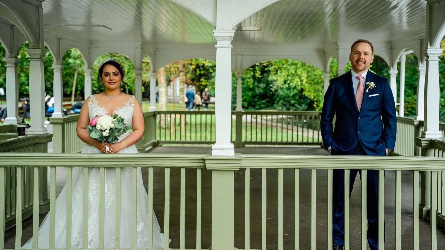 Panoramic view of a white gazebo wedding venue beside a tranquil pond.