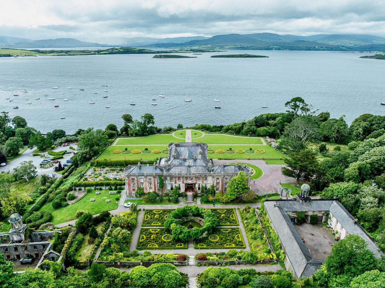 Aerial view of a coastal estate with manicured gardens and surrounding water views.