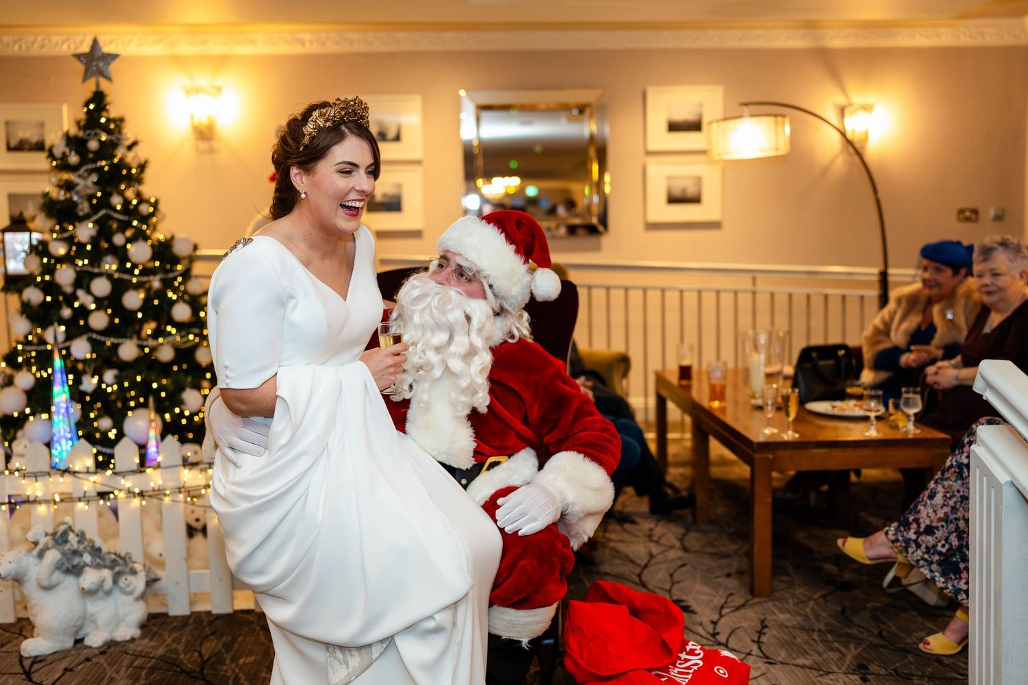 Festive Christmas gathering with decorated trees and holiday ambiance in warm indoor setting.