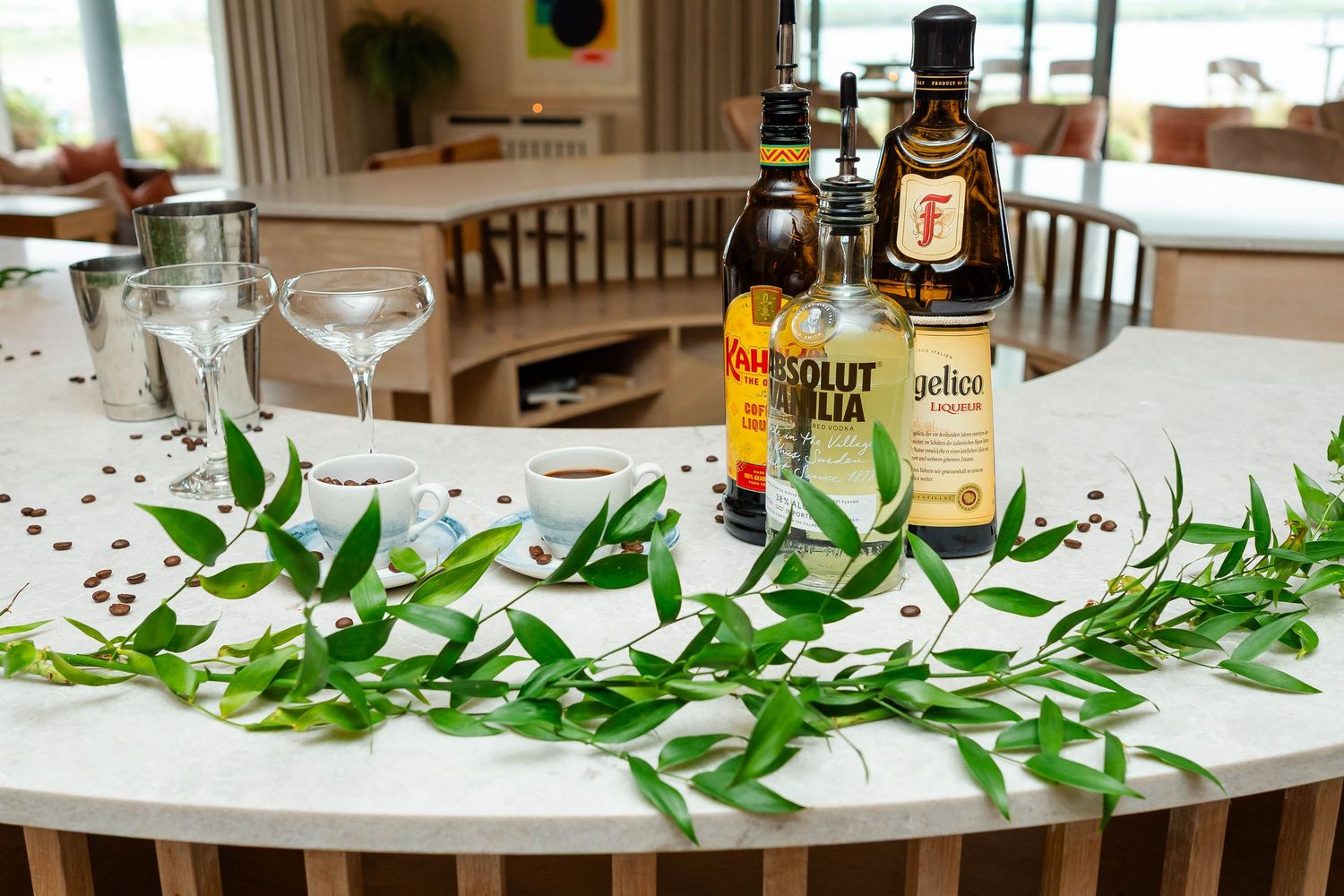 Wedding reception table decorated with green garland and drink bottles.