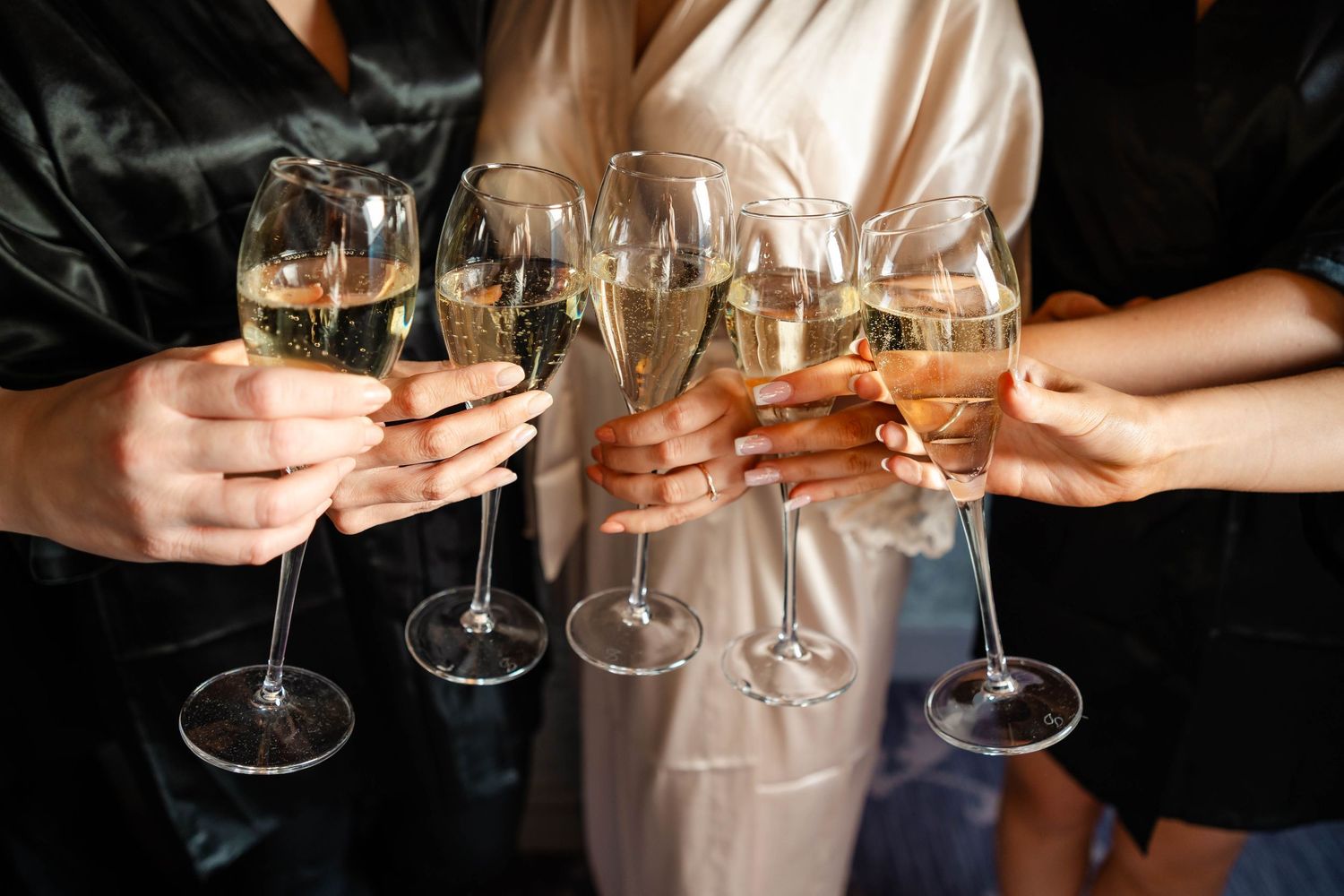 Close-up of hands holding wine glasses in a celebratory toast.