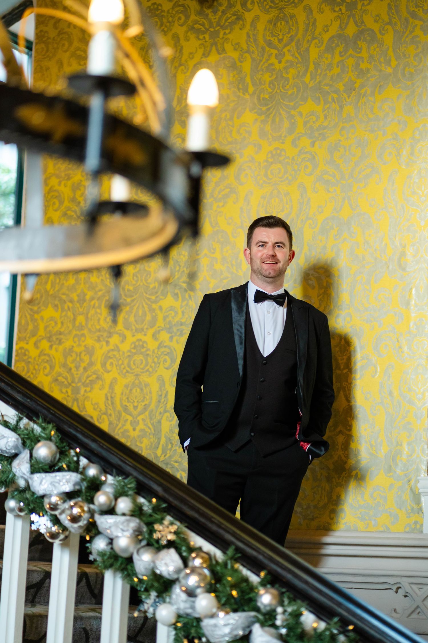 Formal portrait on staircase decorated with holiday ornaments and garland.