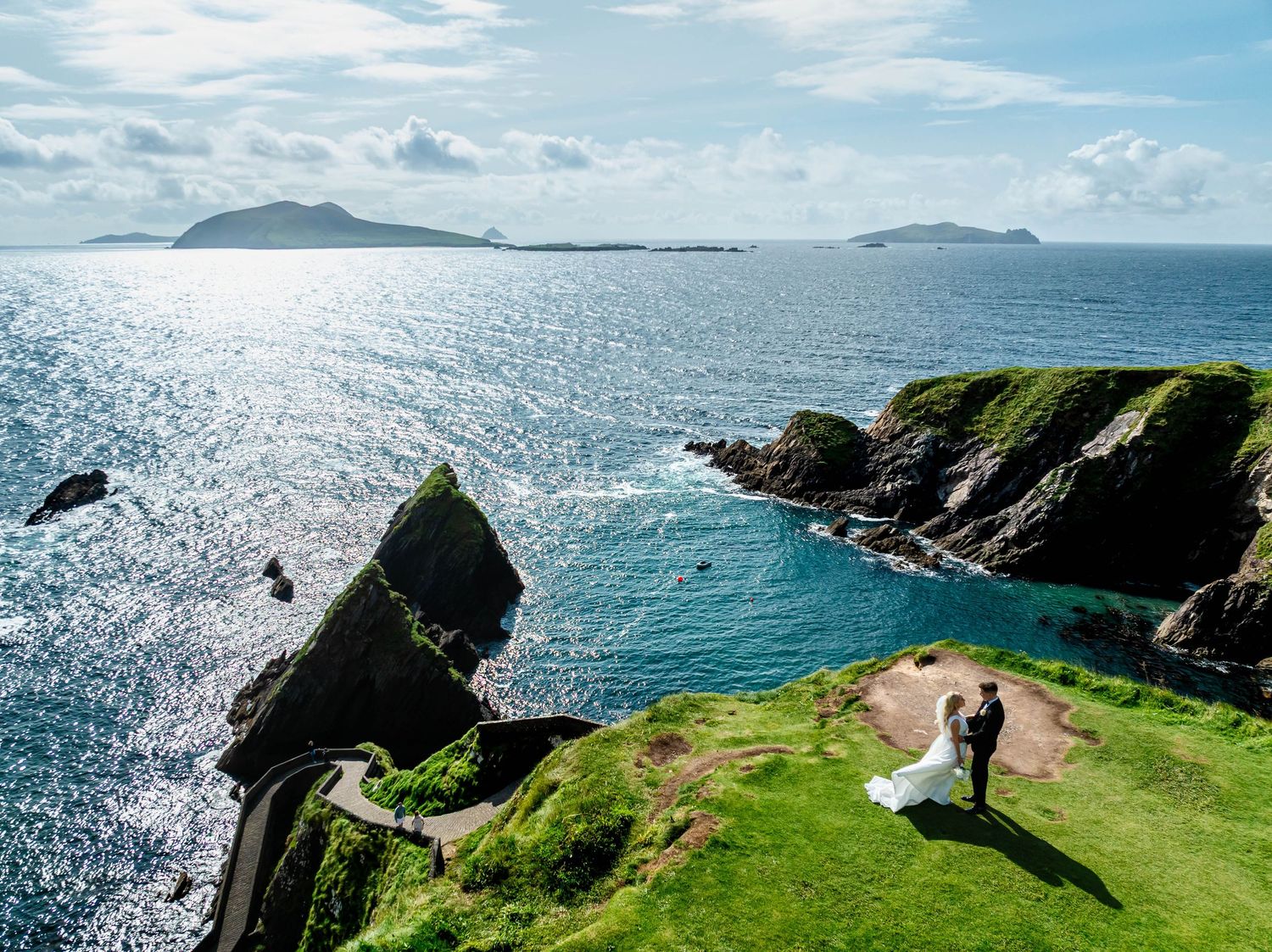 Stunning coastal landscape with green cliffs overlooking a sparkling blue ocean.