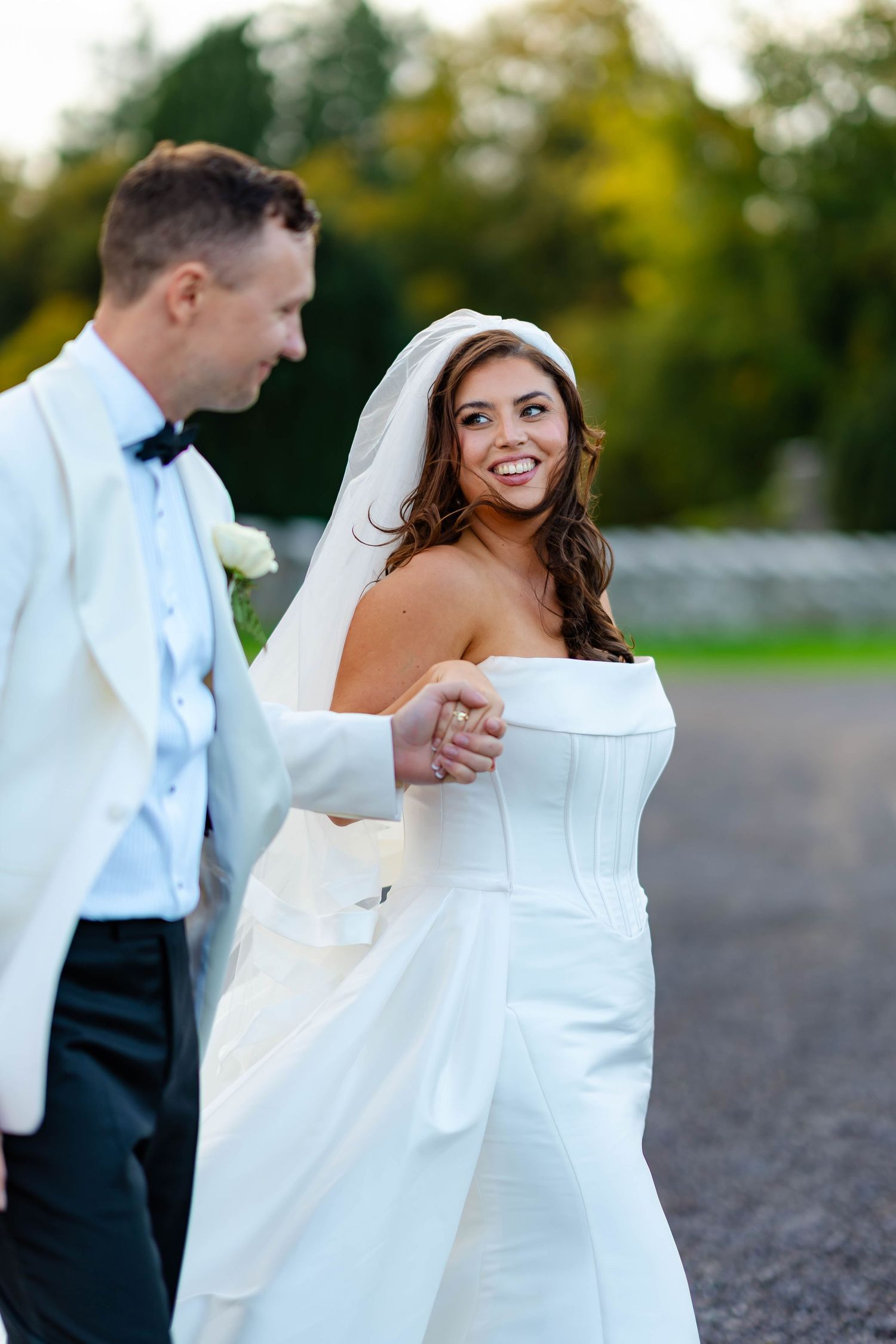 A bride and groom share a romantic moment outdoors during their wedding photoshoot.