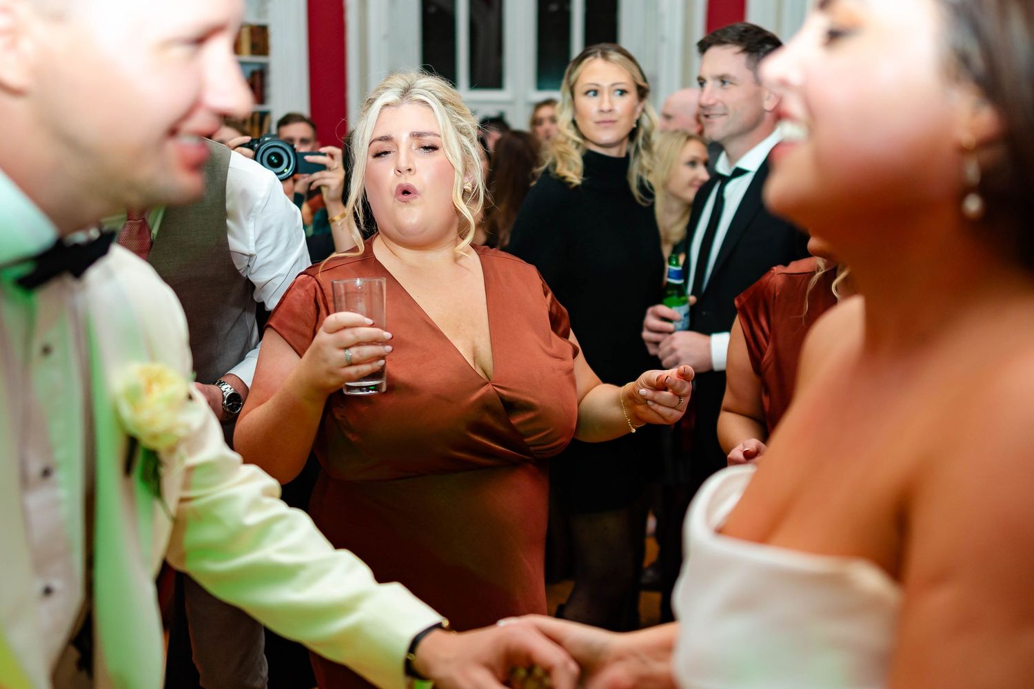Wedding guests enjoy drinks and dancing during a lively reception celebration.