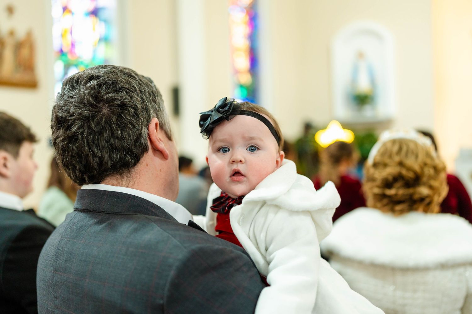 Church ceremony with stained glass windows and guests in attendance.