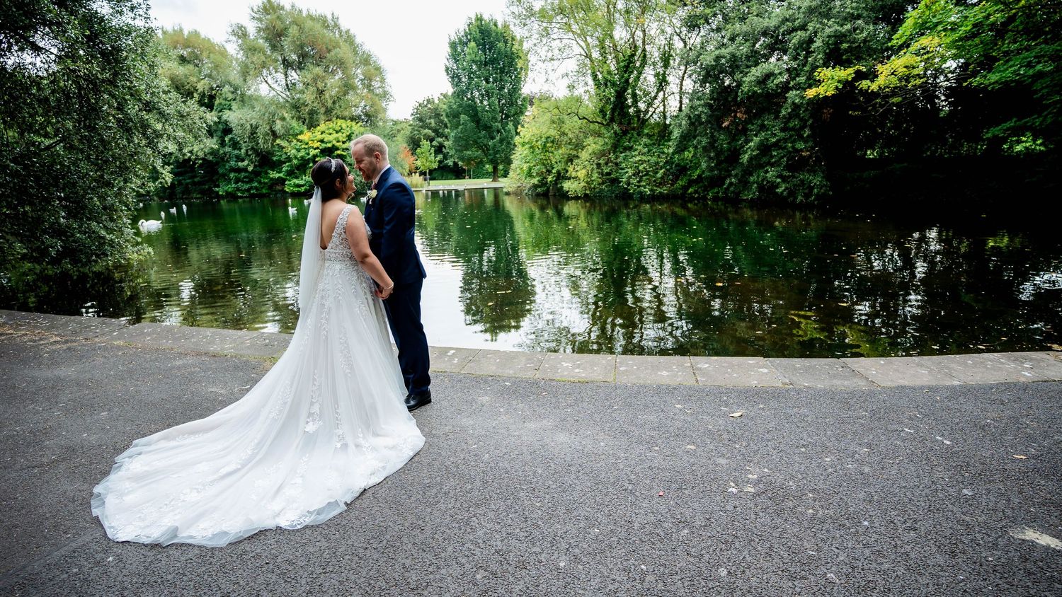 A panoramic view of a wedding venue with trees and water in the background.